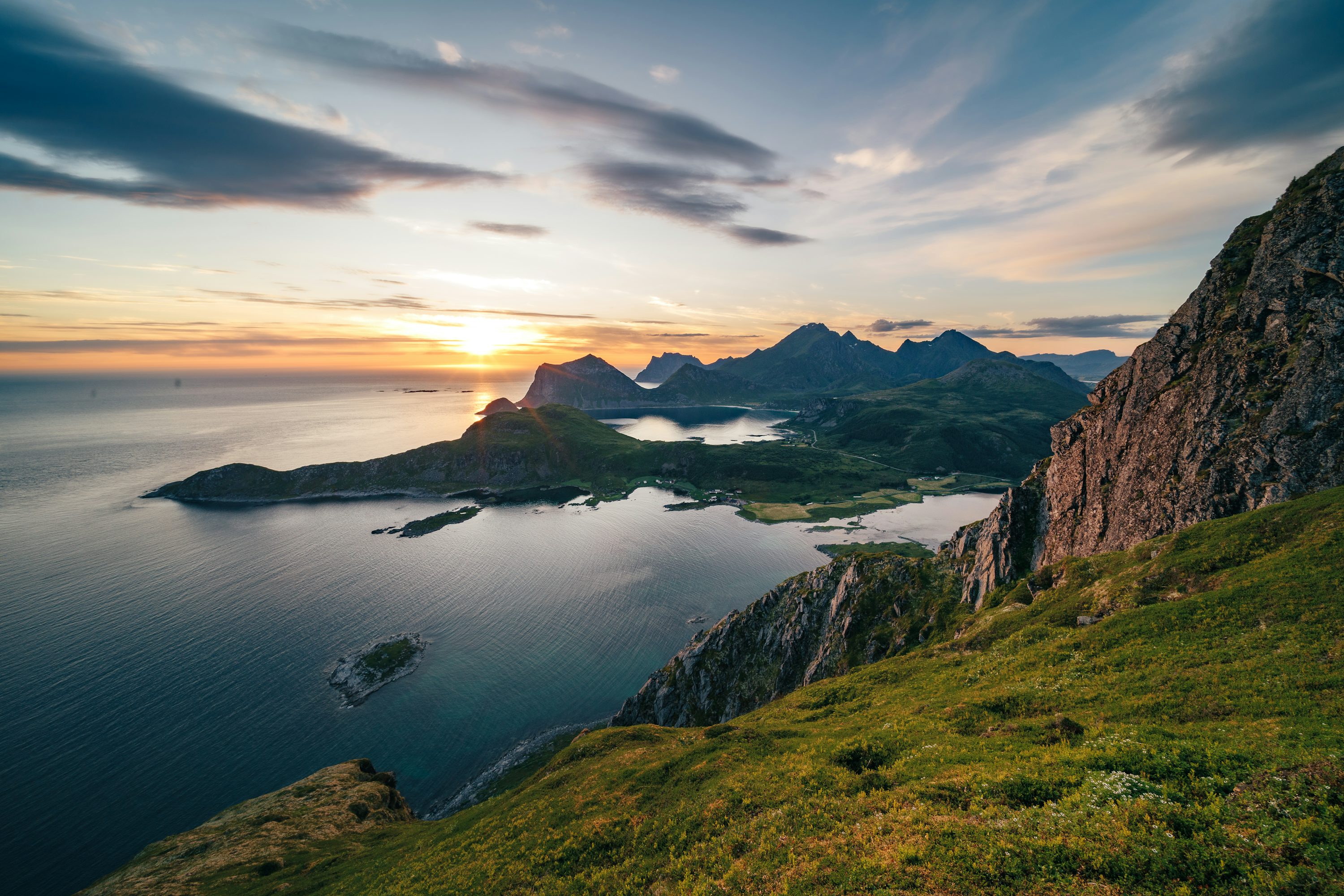 The sun is setting over the mountains and the water photo