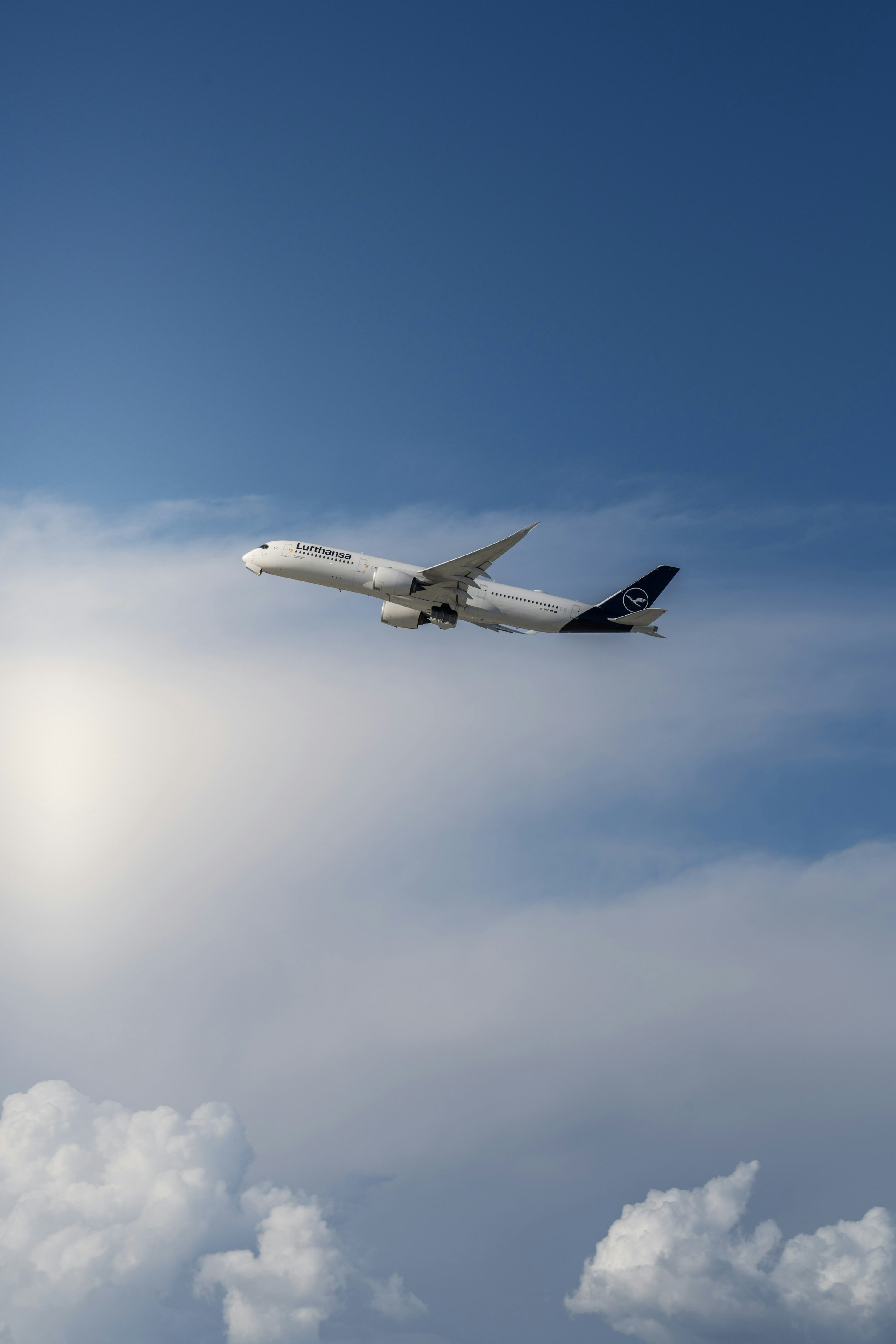 A large jetliner flying through a blue cloudy sky photo