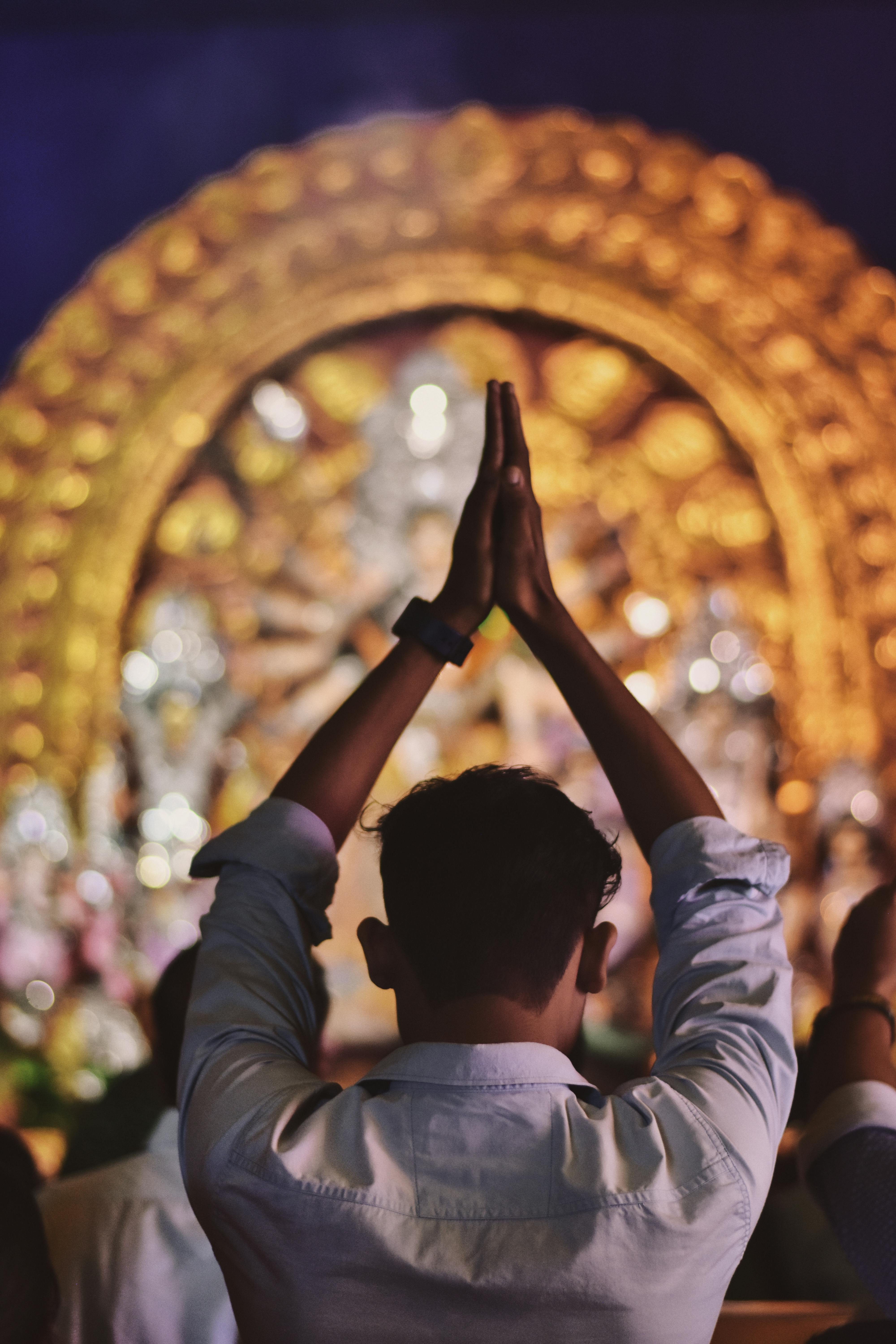 Man with Hands Folded Above His Head Praying in a Hindu Temple · Free