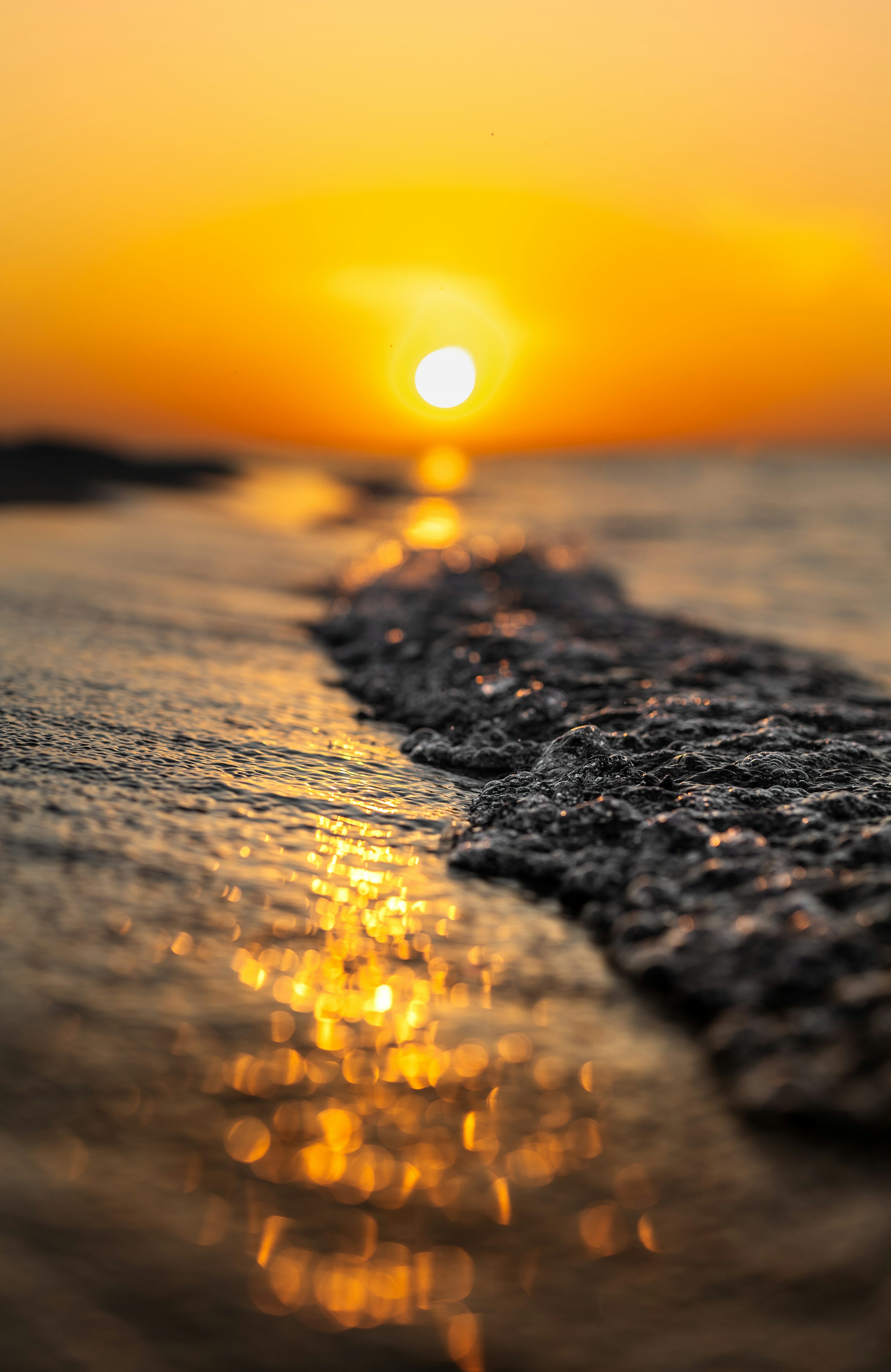 The sun is setting over the water at the beach photo