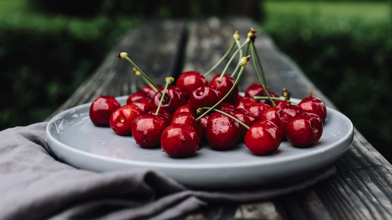 Download wallpaper 1366x768 cherries, cherry, dish, motion blur tablet, laptop HD background