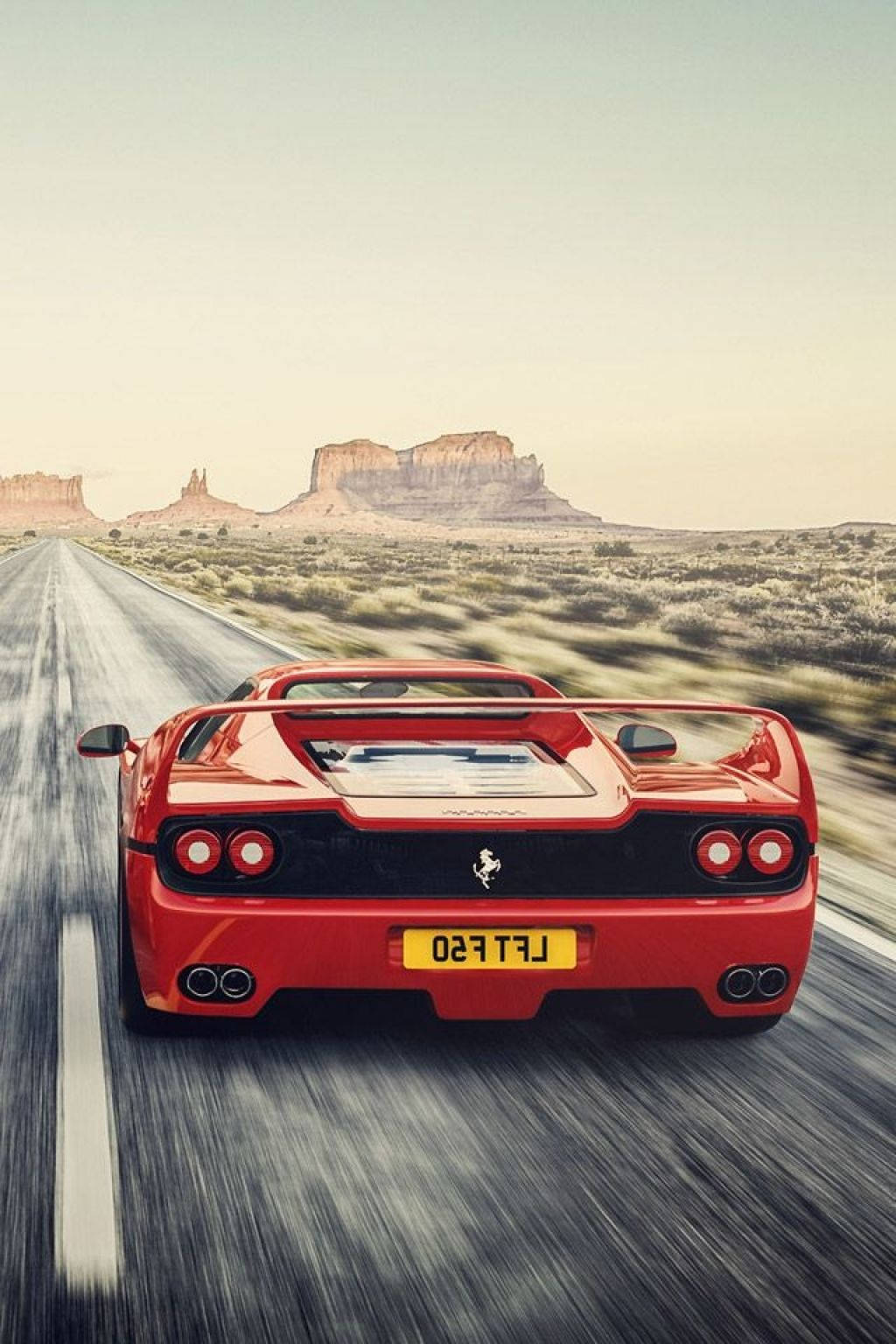 Download Red F50 Ferrari Phone On Dessert Road Wallpaper