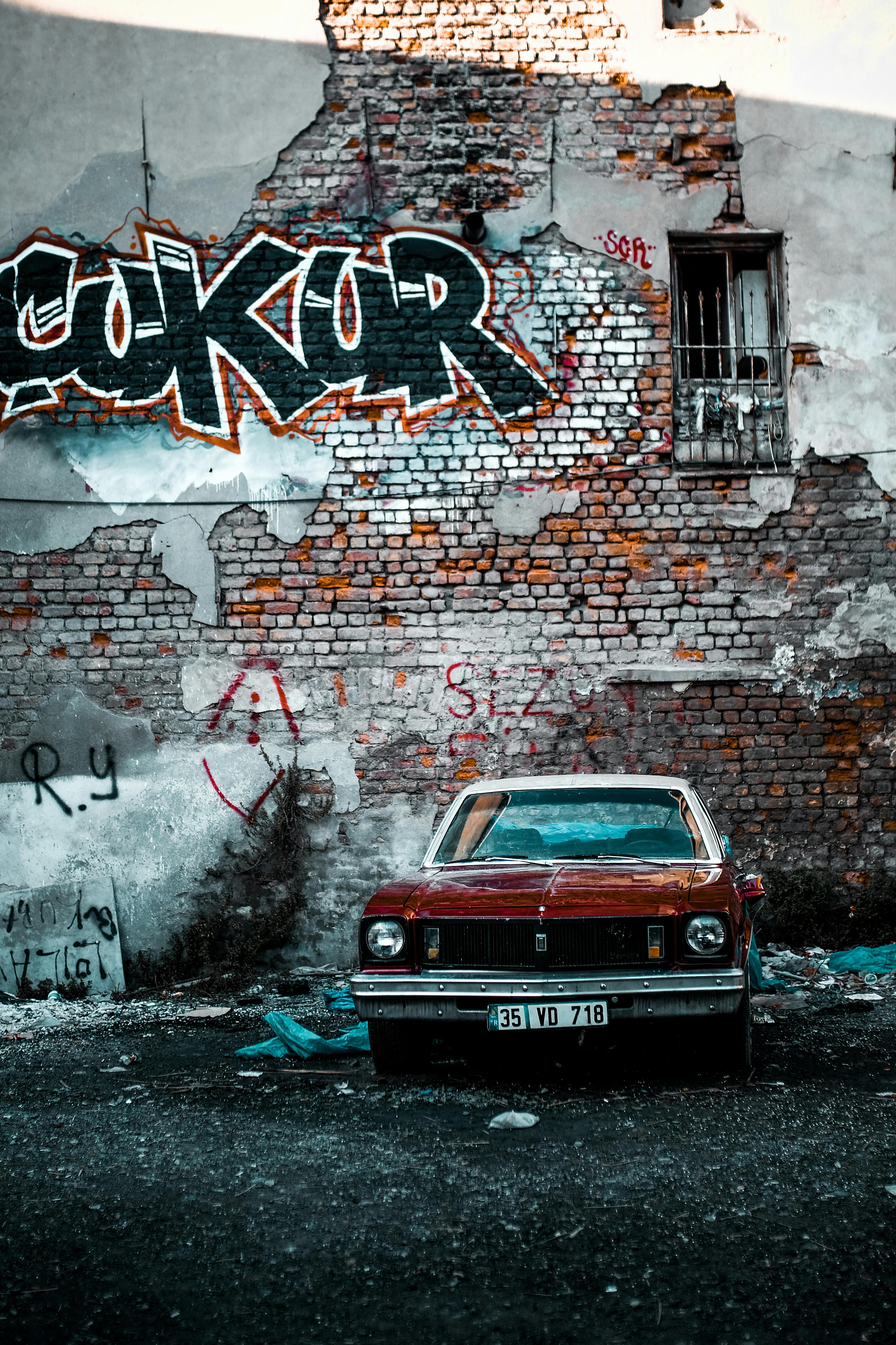 Vintage Car Parked Under Wall Covered in Graffiti · Free