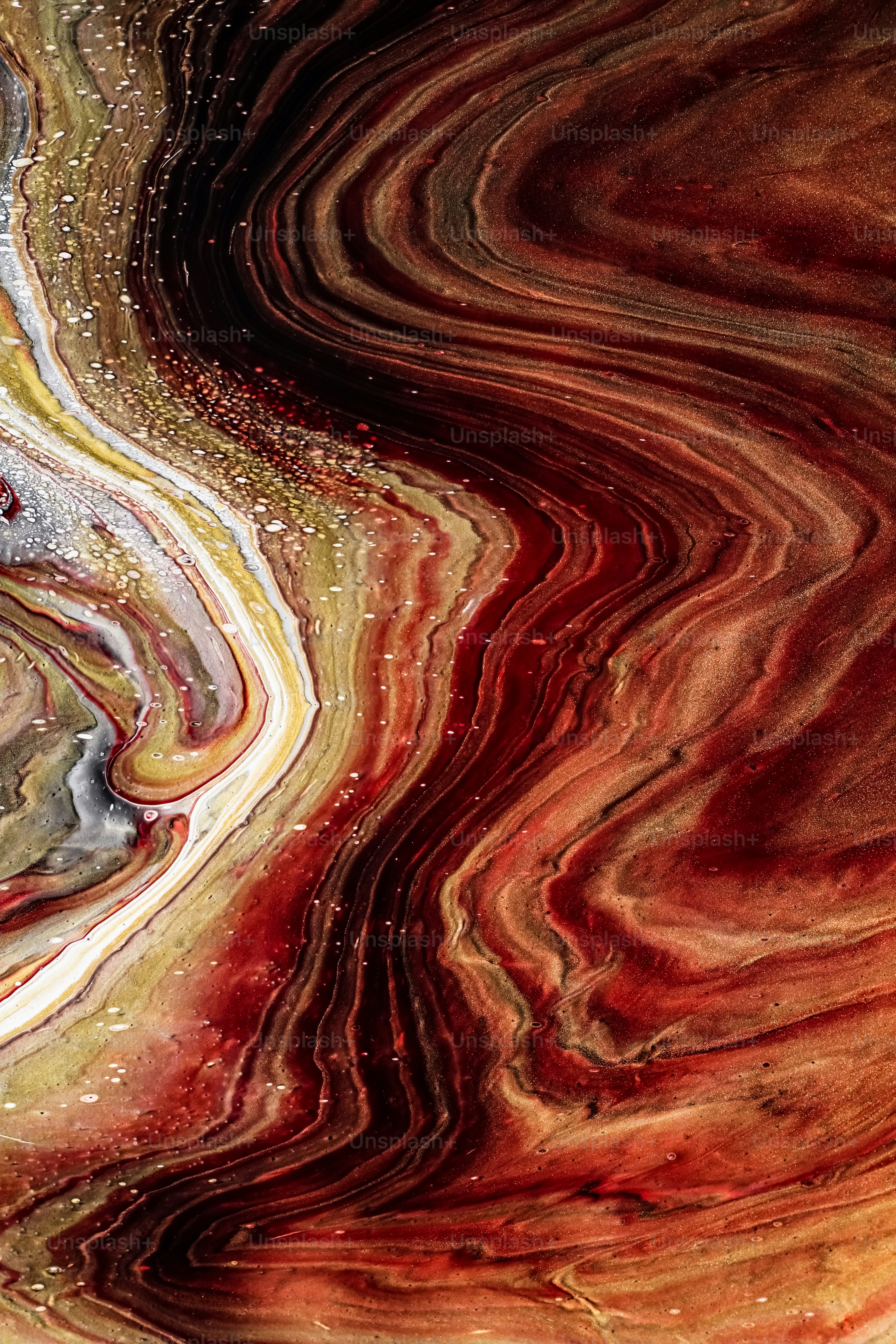 A close up of a red, yellow, and black swirl photo