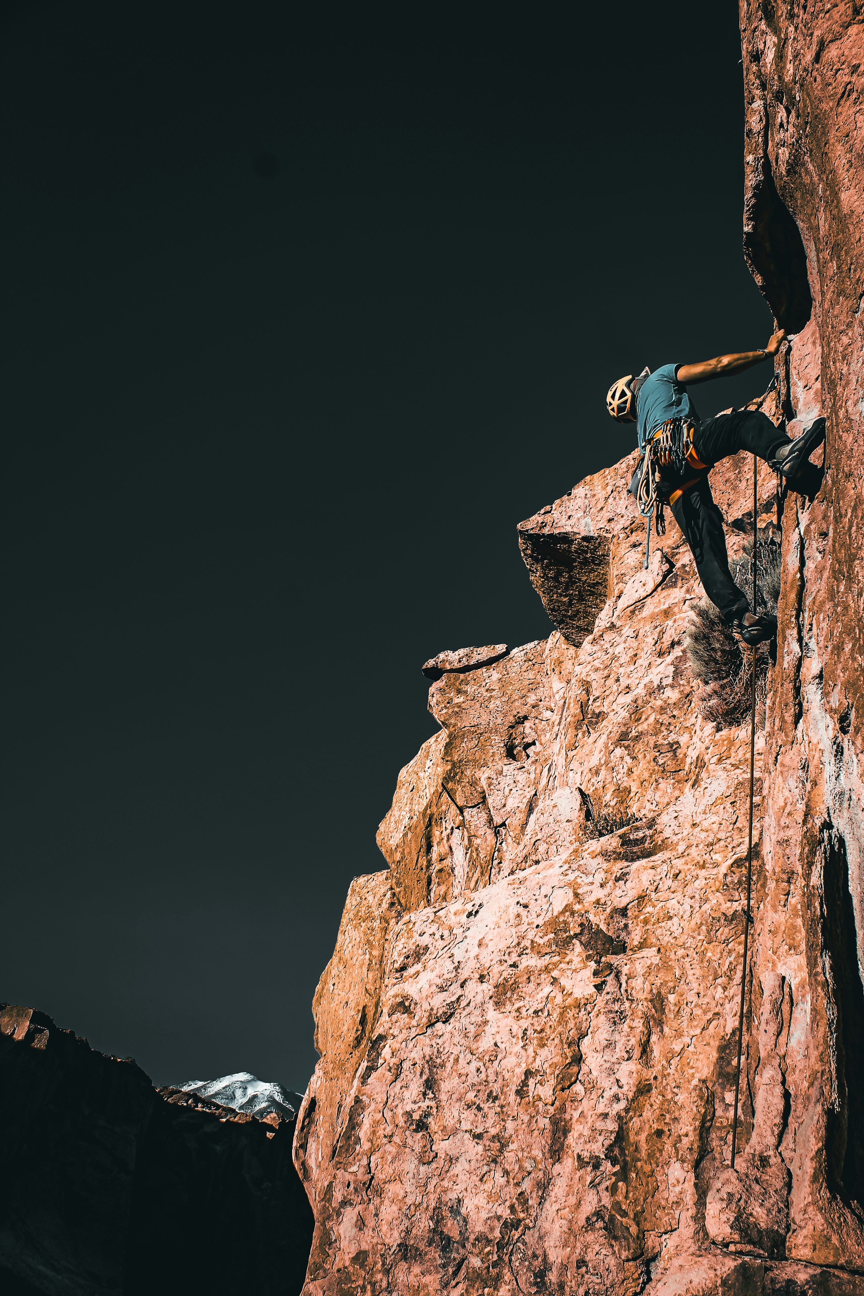 A man climbing up the side of a mountain photo