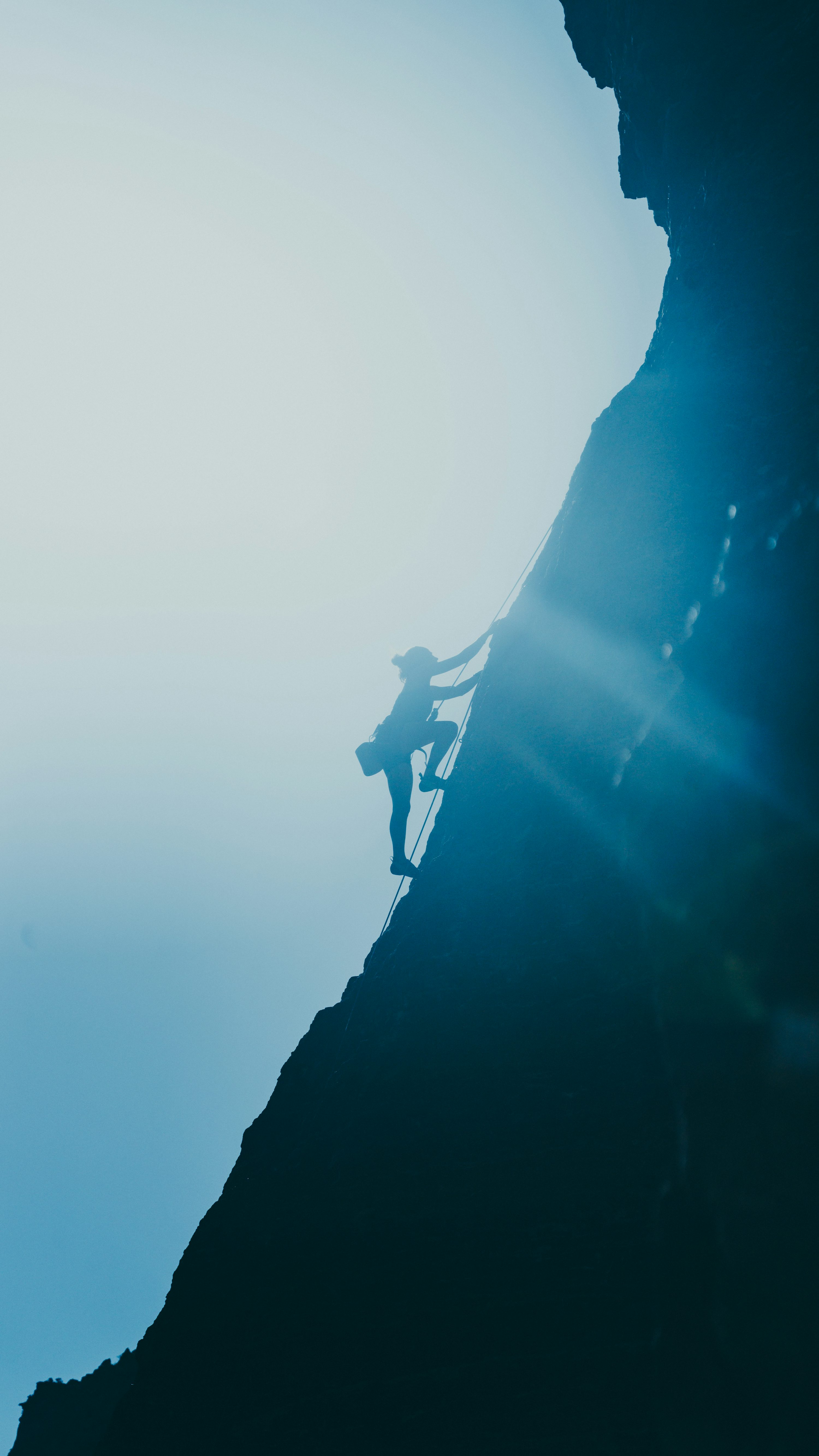 Silhouette of man standing on rock formation during daytime photo