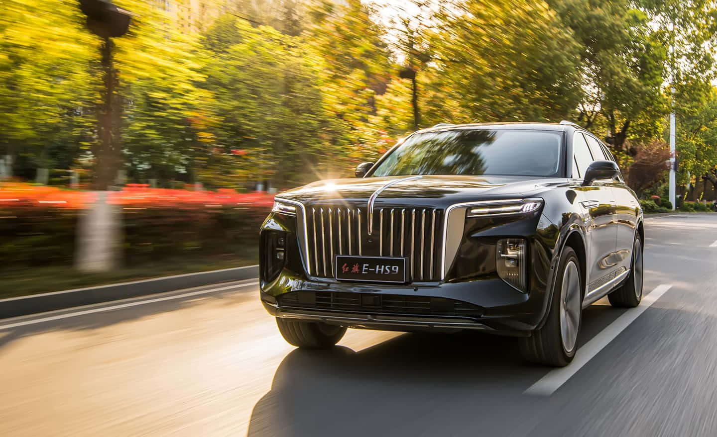 Download Luxurious Red Hongqi Sedan Cruising Through Urban Streets Wallpaper