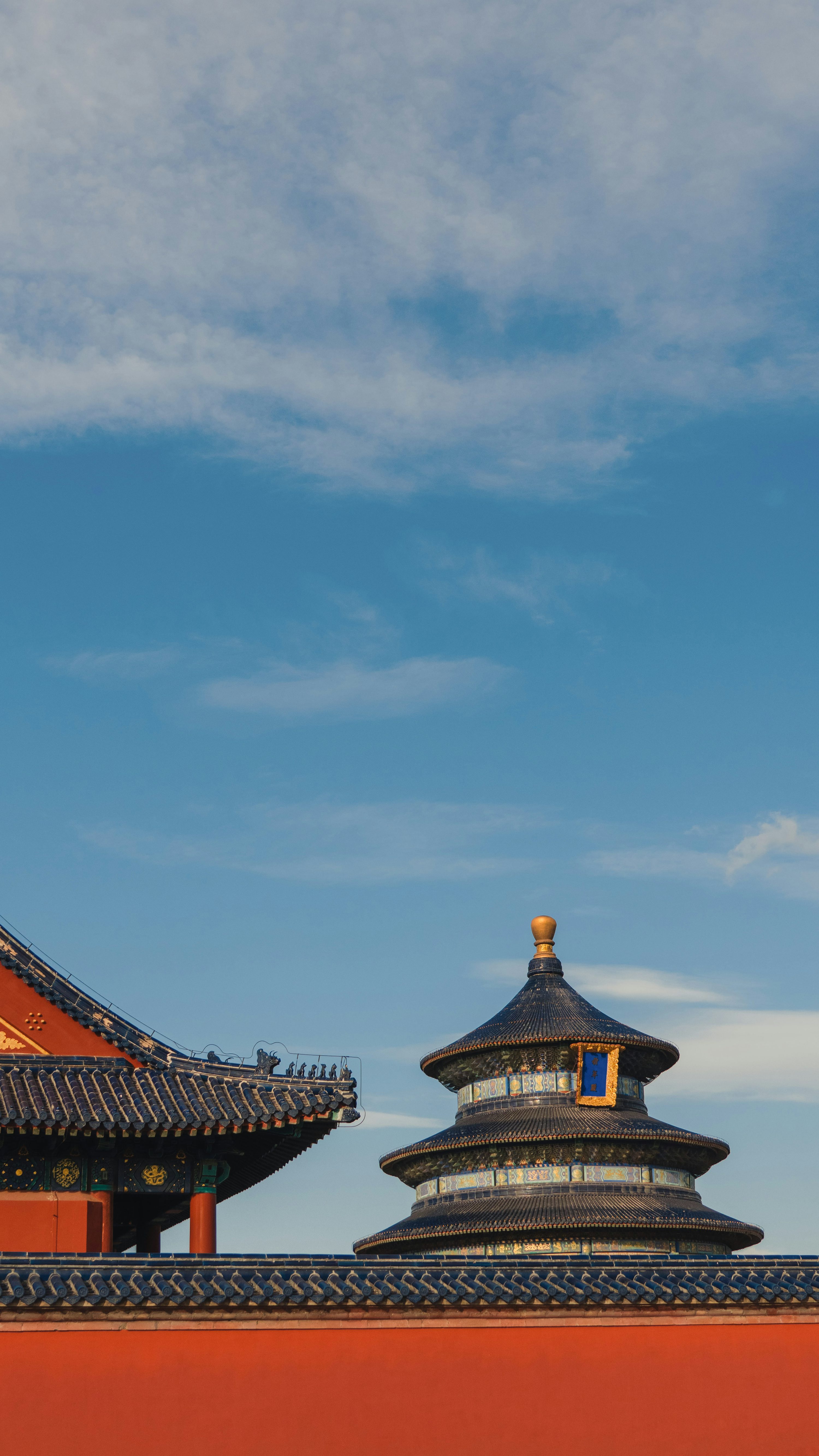 A red wall with a clock tower in the background photo
