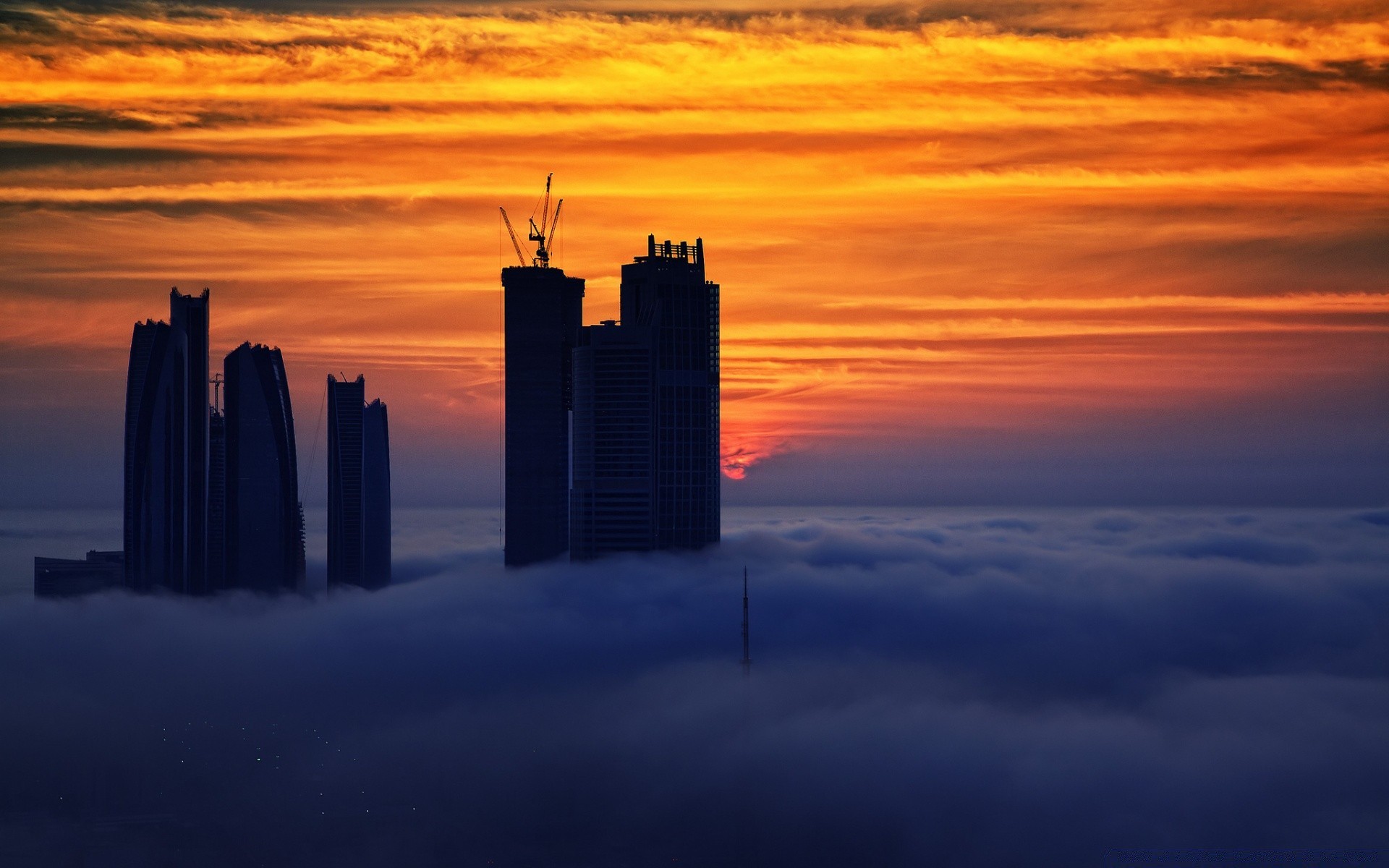 Silhouette of futuristic buildings against the background of a fiery sunset