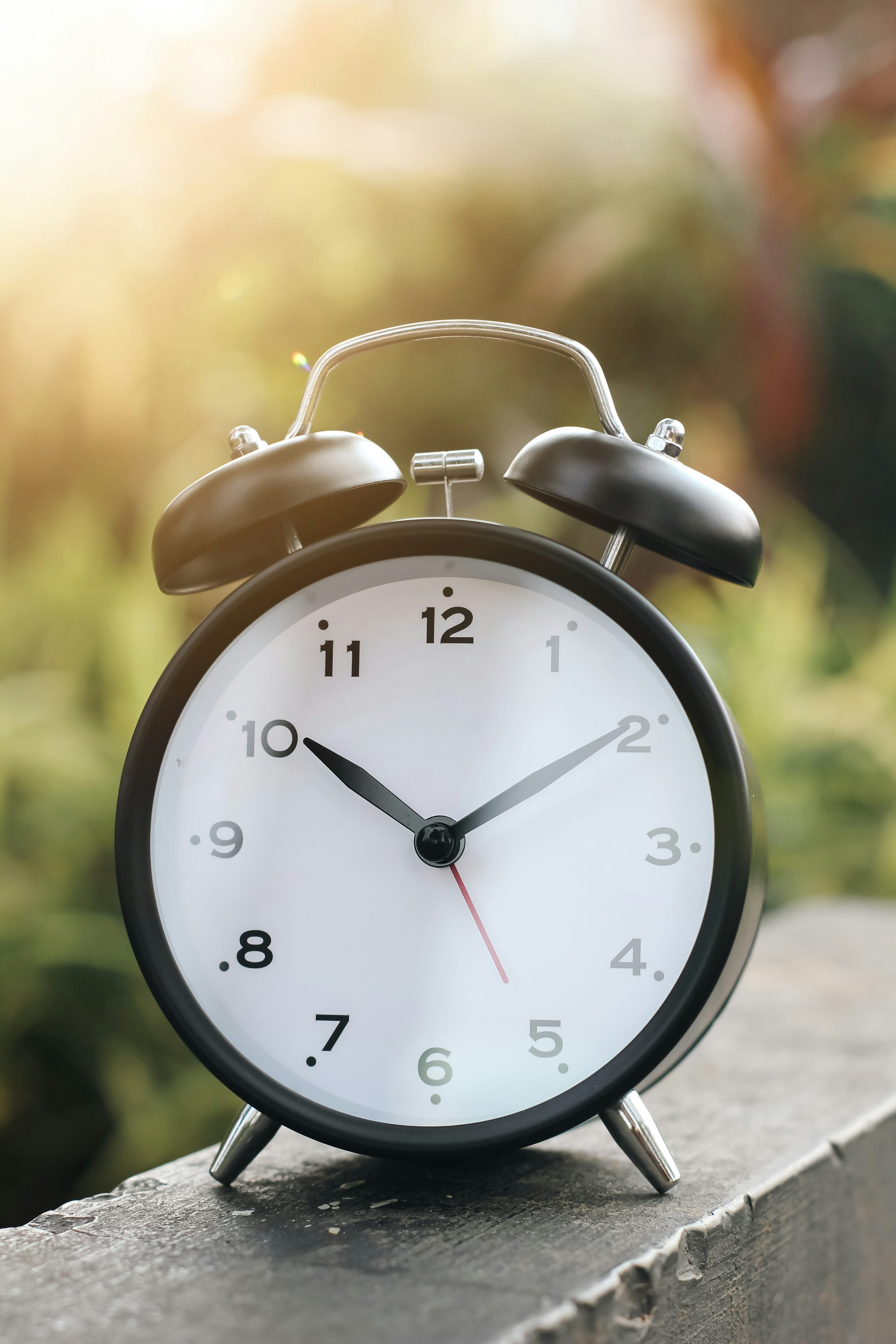 A black and white alarm clock sitting on a ledge photo
