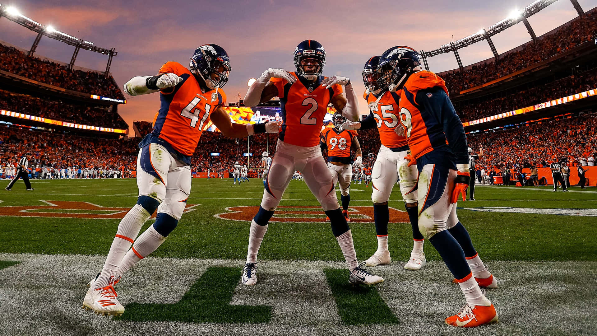 Download Broncos Players Celebratingon Field Wallpaper