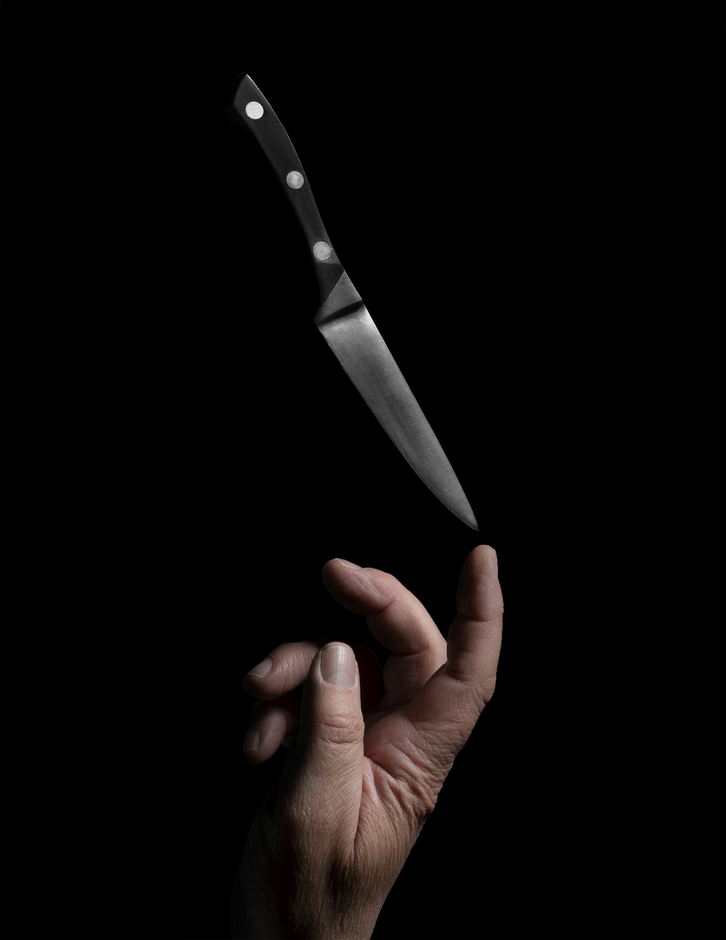 Person holding stainless steel bread knife photo
