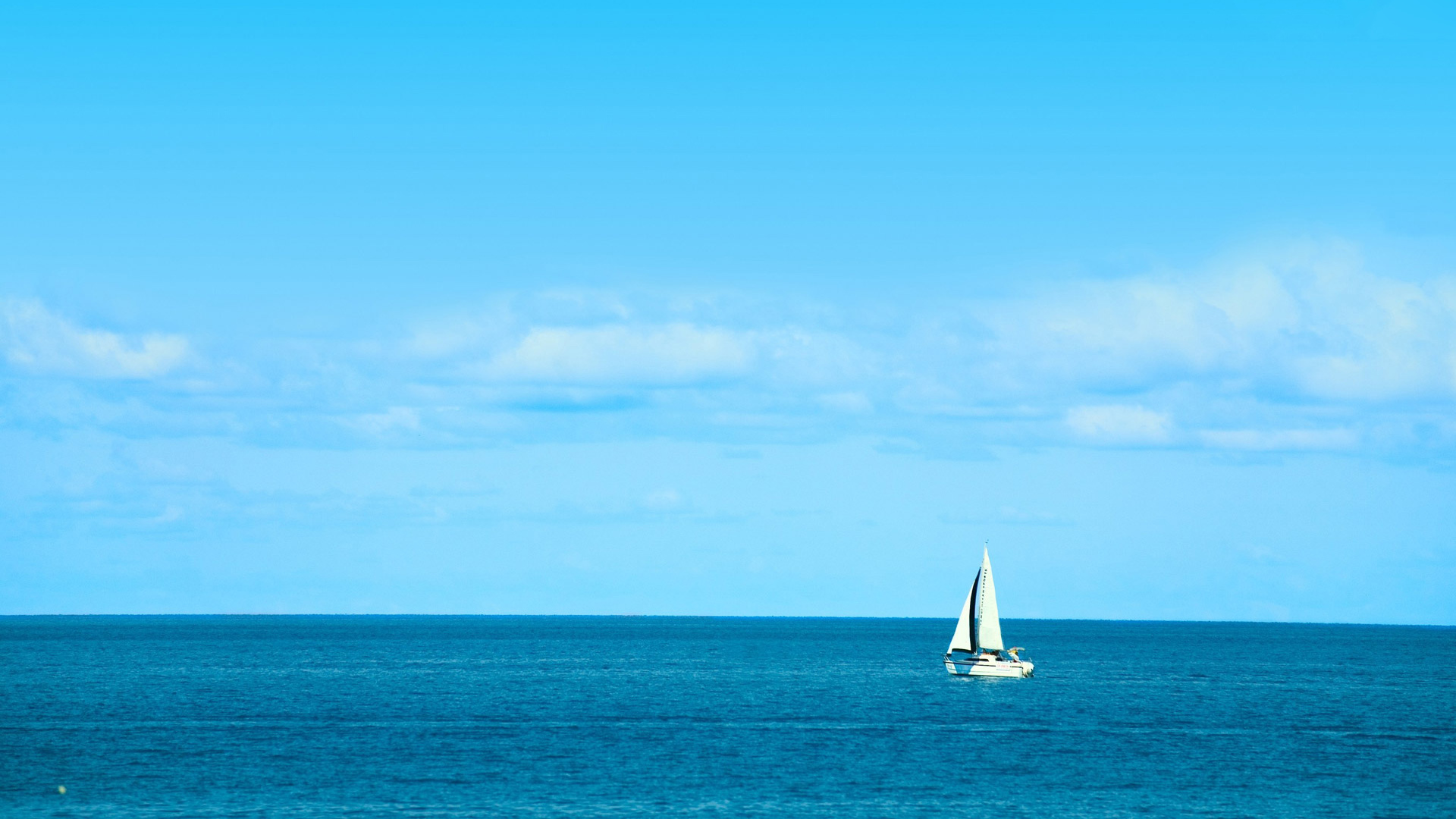 White Sailboat on Blue Ocean Beach Background