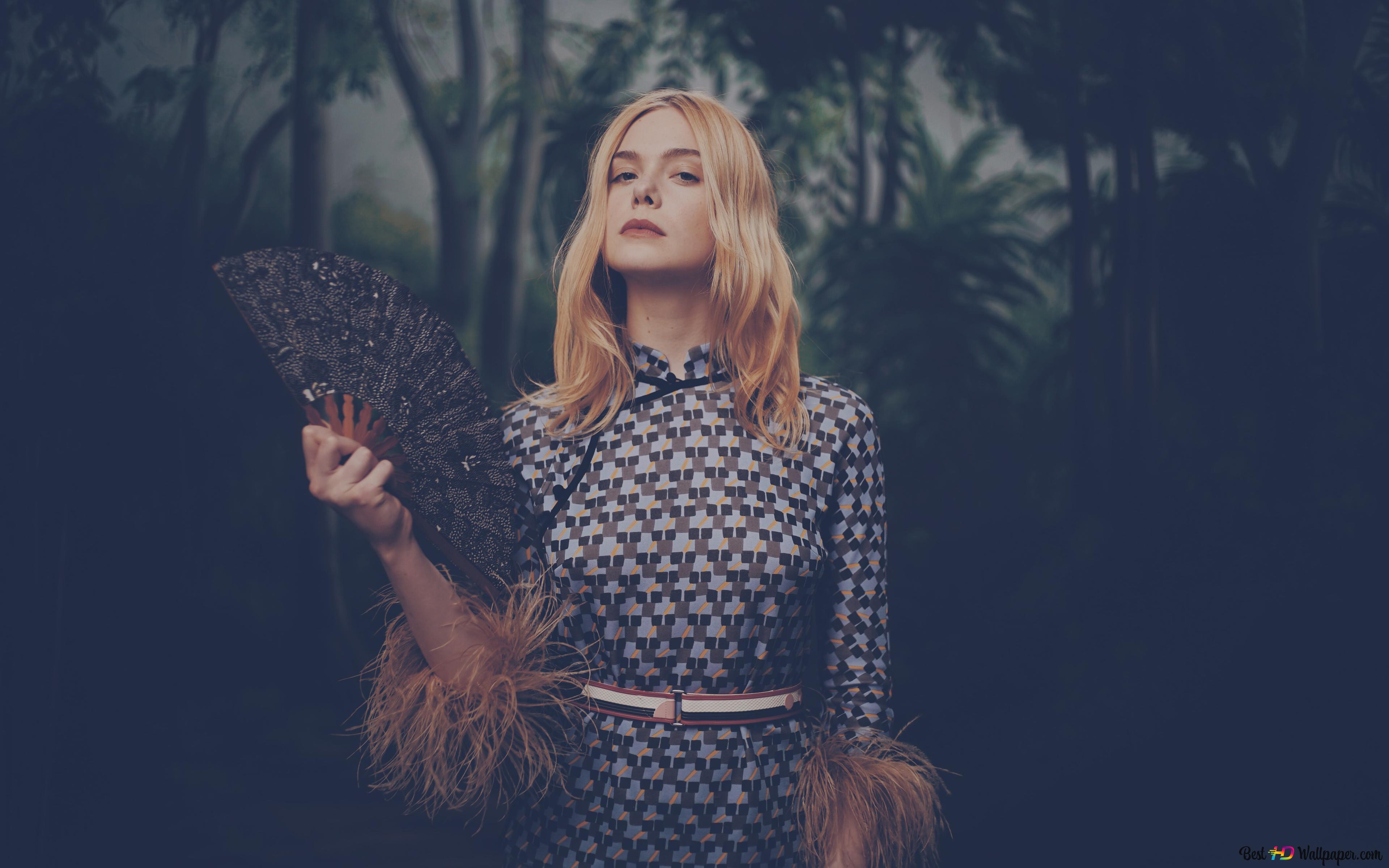 Elle Fanning holding a fan with a forest 4K wallpaper download