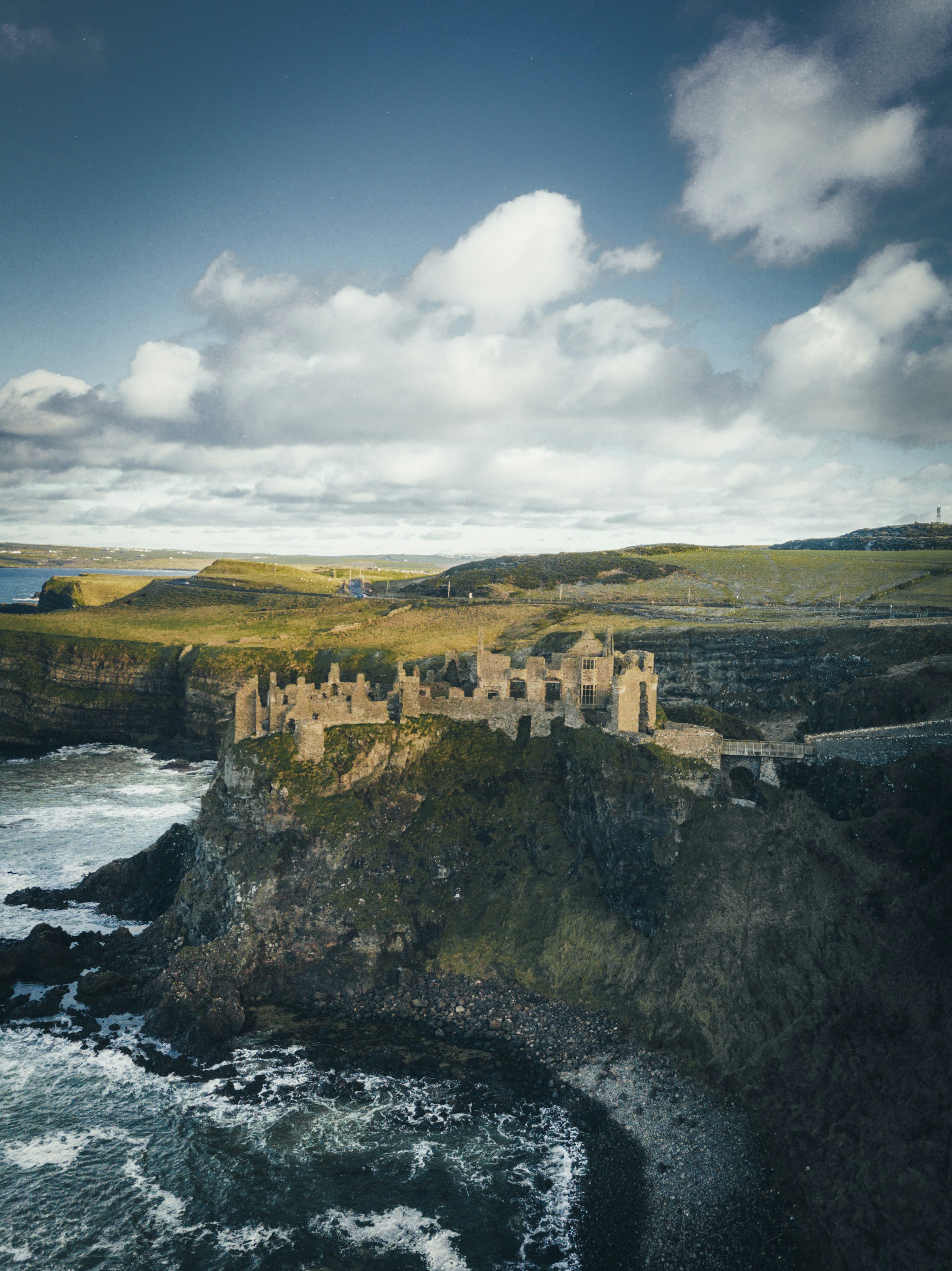 Concrete castle on cliff near body of water during daytime photo
