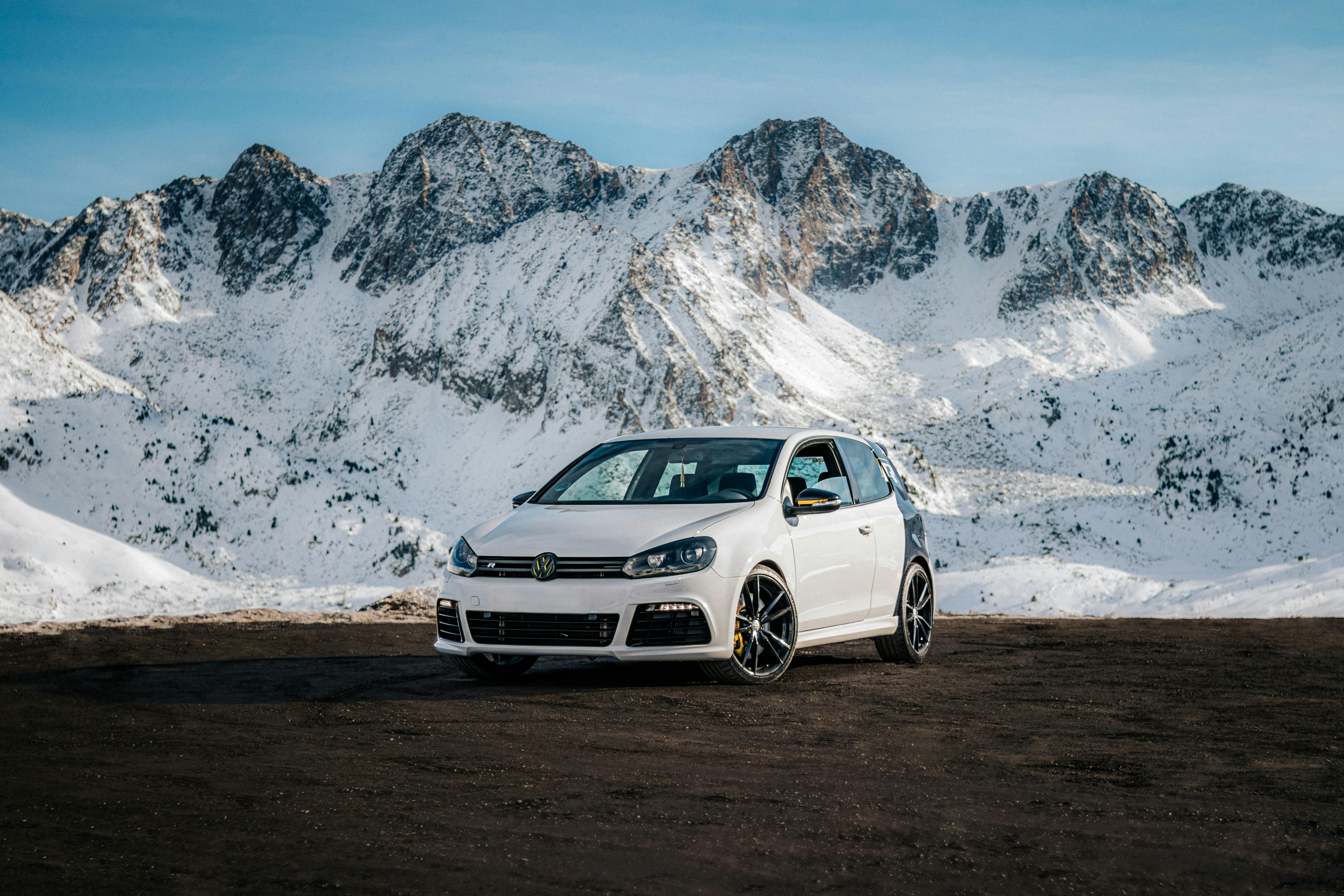 Volkswagen Golf VI on the Background of Snowy Mountains · Free