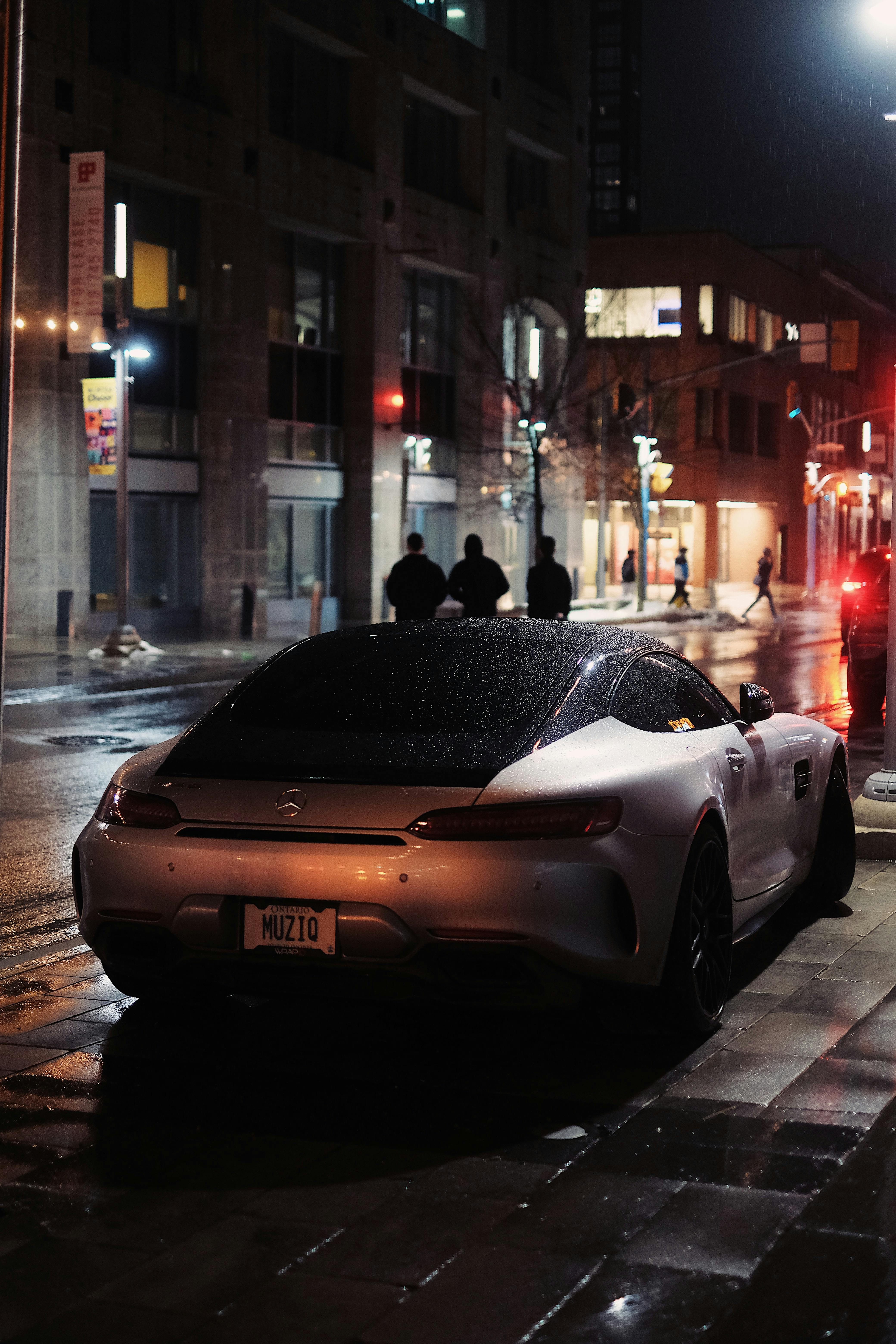 Silver Mercedes AMG GT Parked On The Sidewalk On A Rainy Night · Free