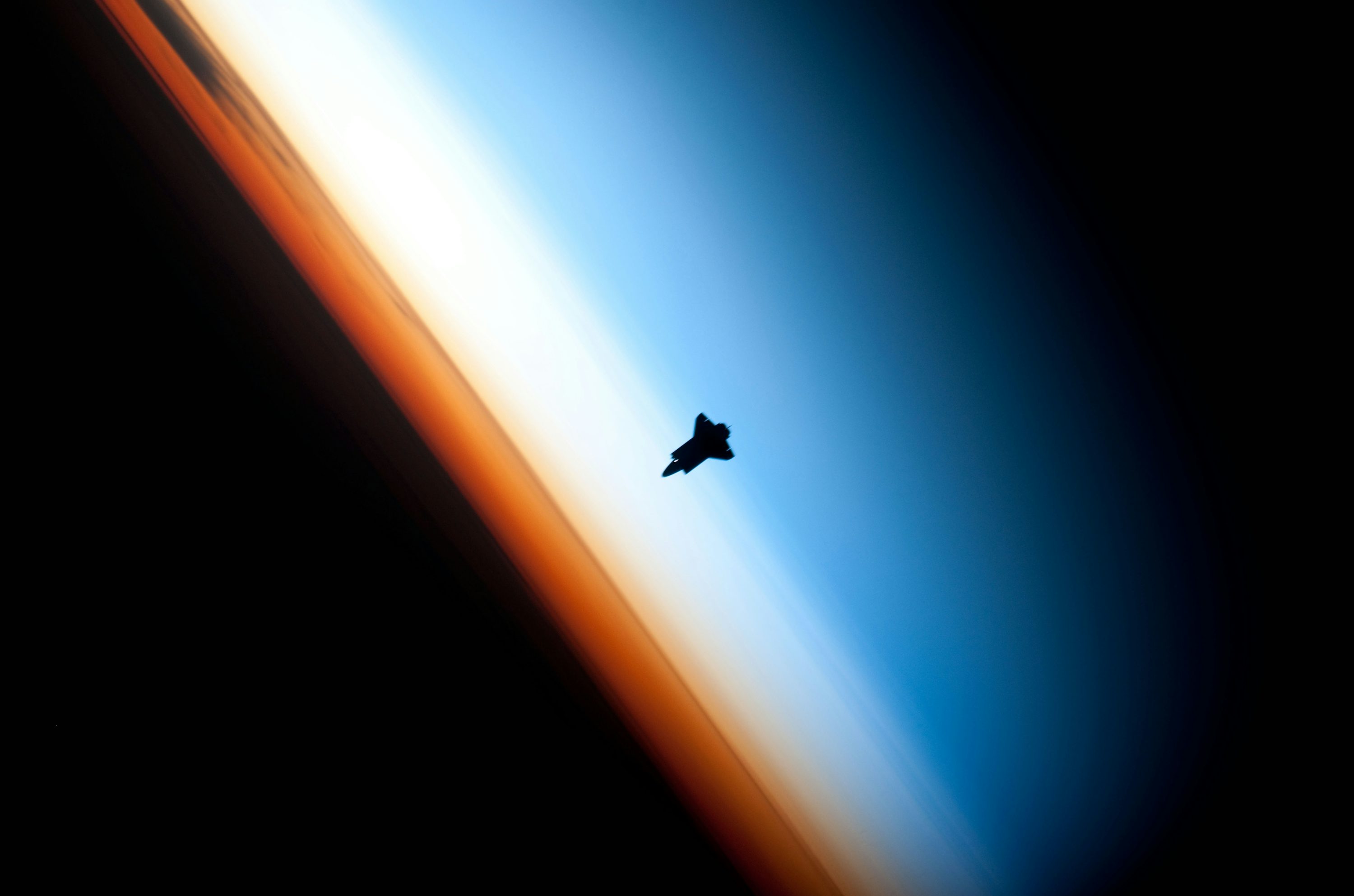 Space Shuttle orbits above earth atmosphere photo