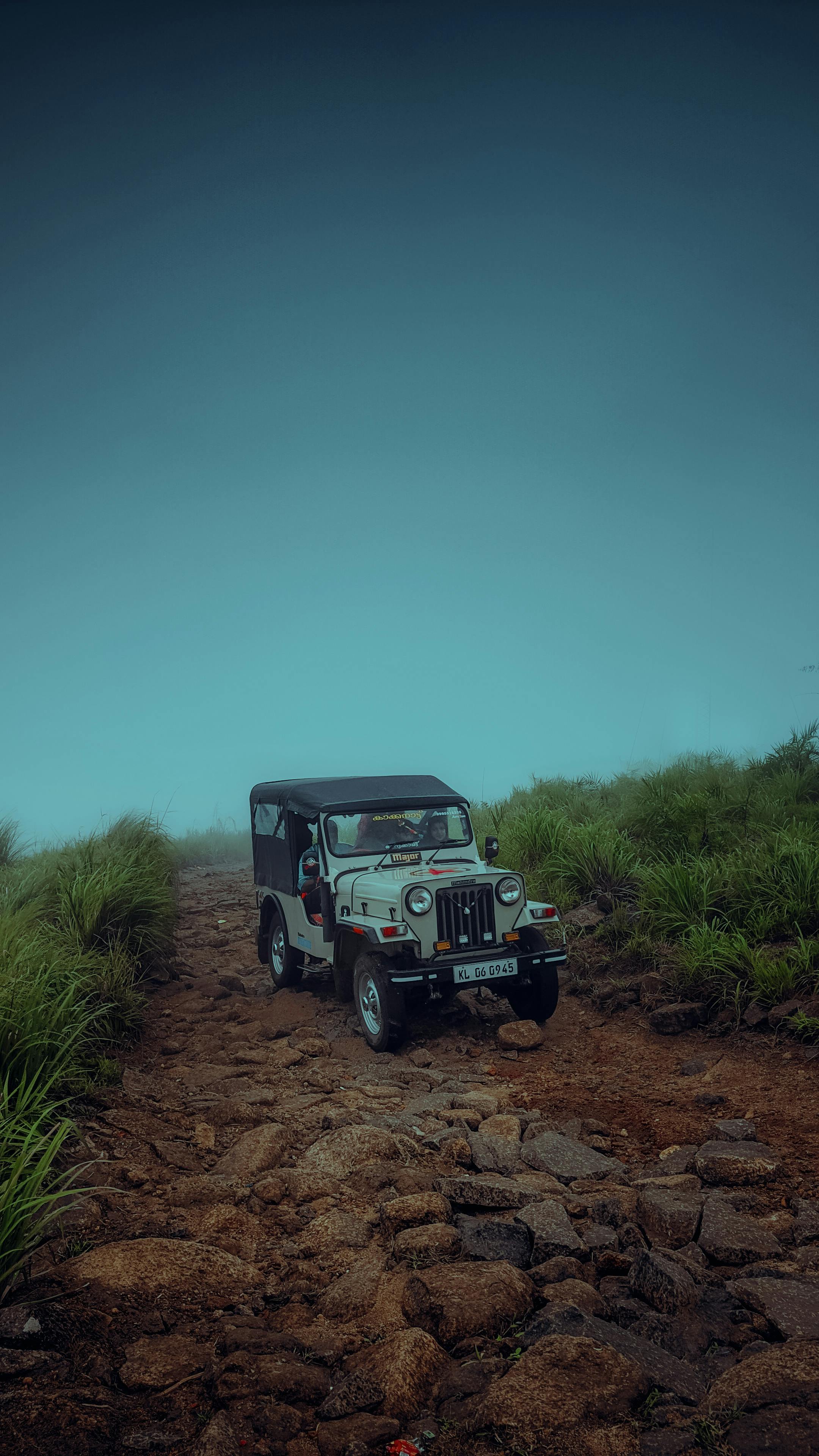 A jeep is driving on a dirt road · Free
