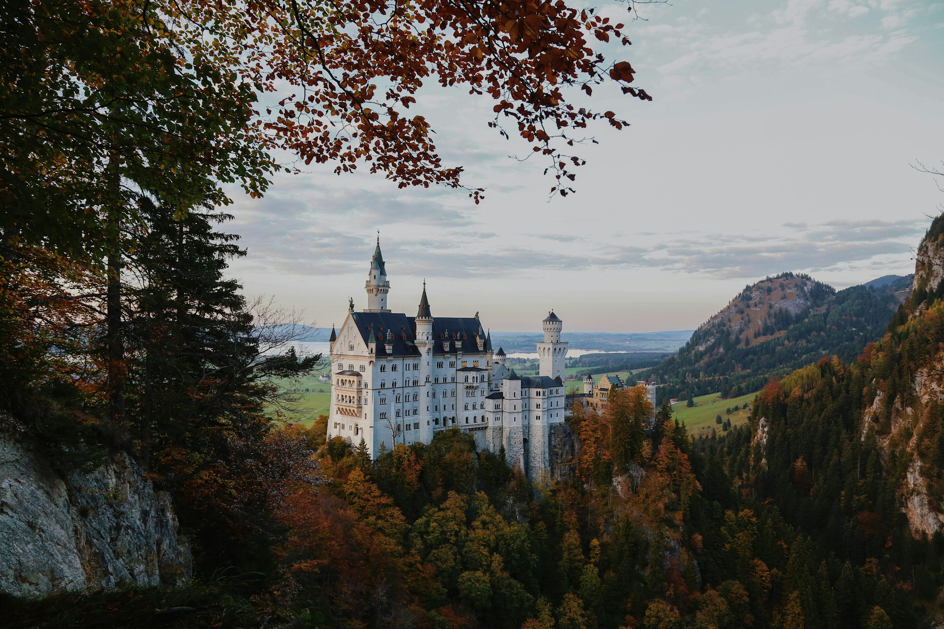 A castle on a hill with Neuschwanstein Castle in the background photo