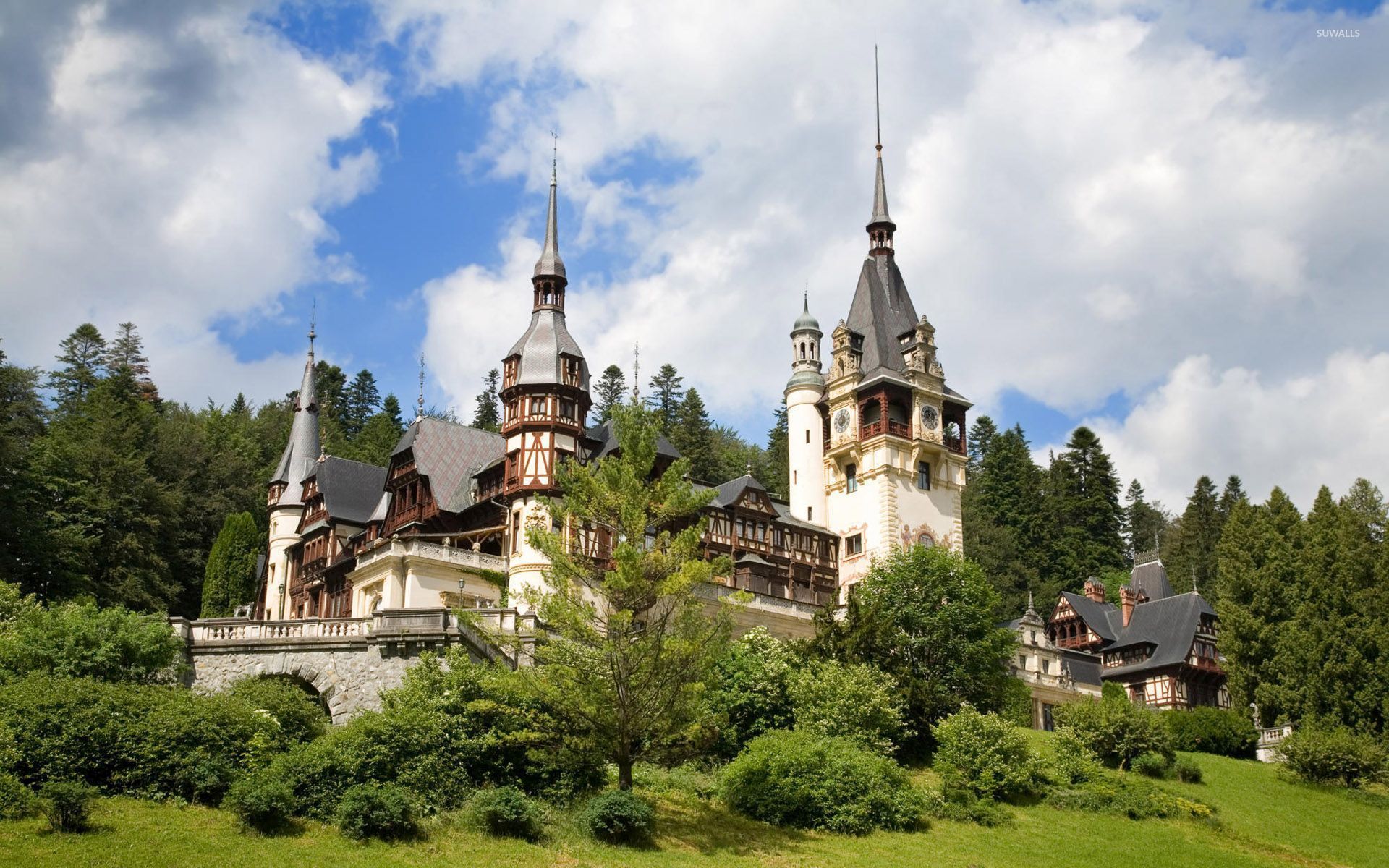 Green forest surrounding Peles Castle wallpaper wallpaper