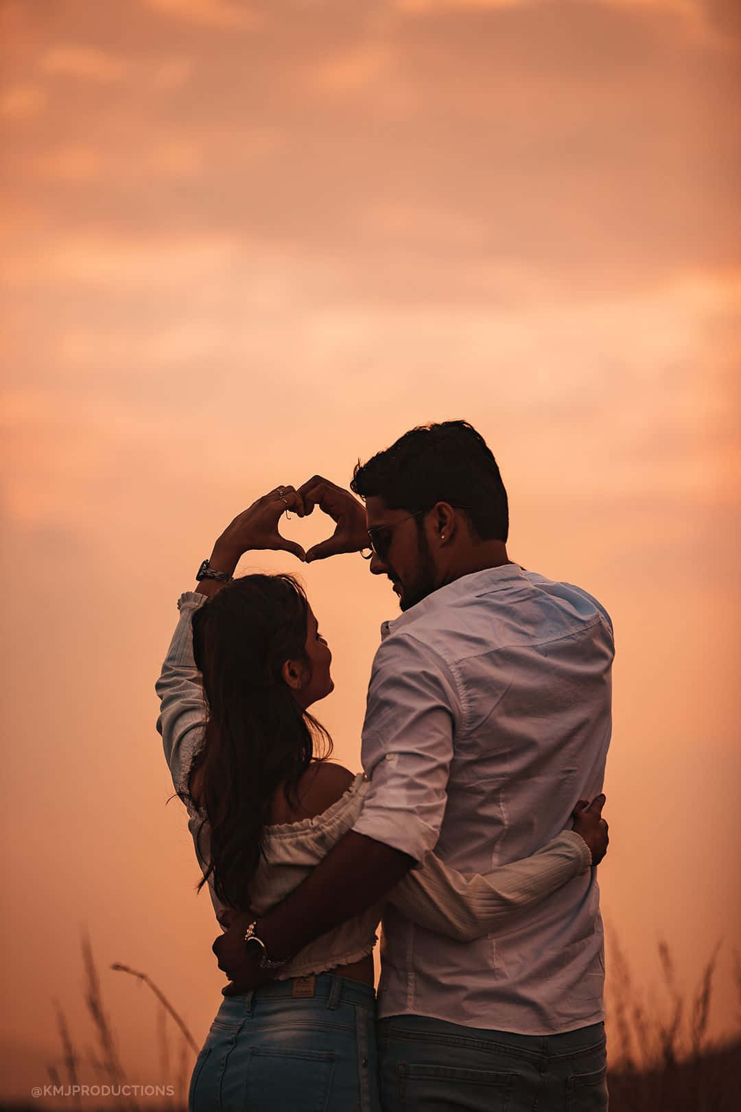 Download Couple Sunset Making Heart On Grass Field Picture