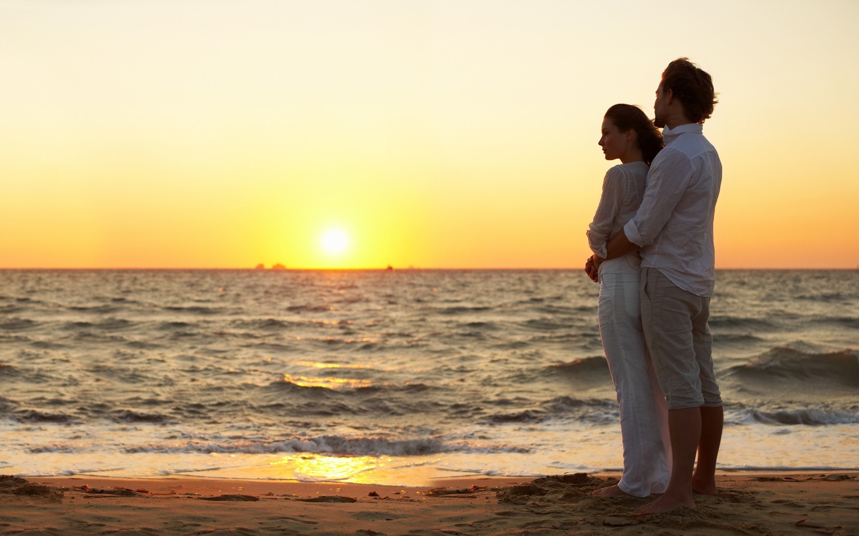 A couple in love on the seashore against the sunset