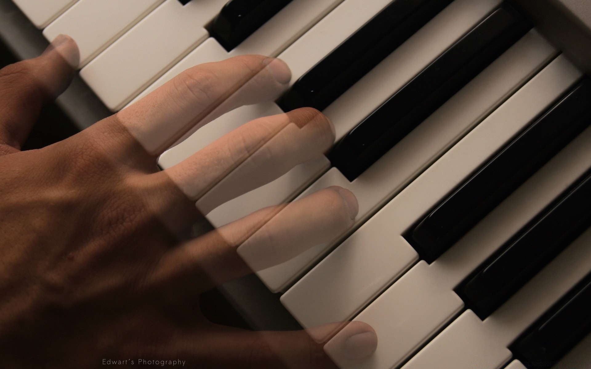 A hand playing on black and white piano keys for your phone