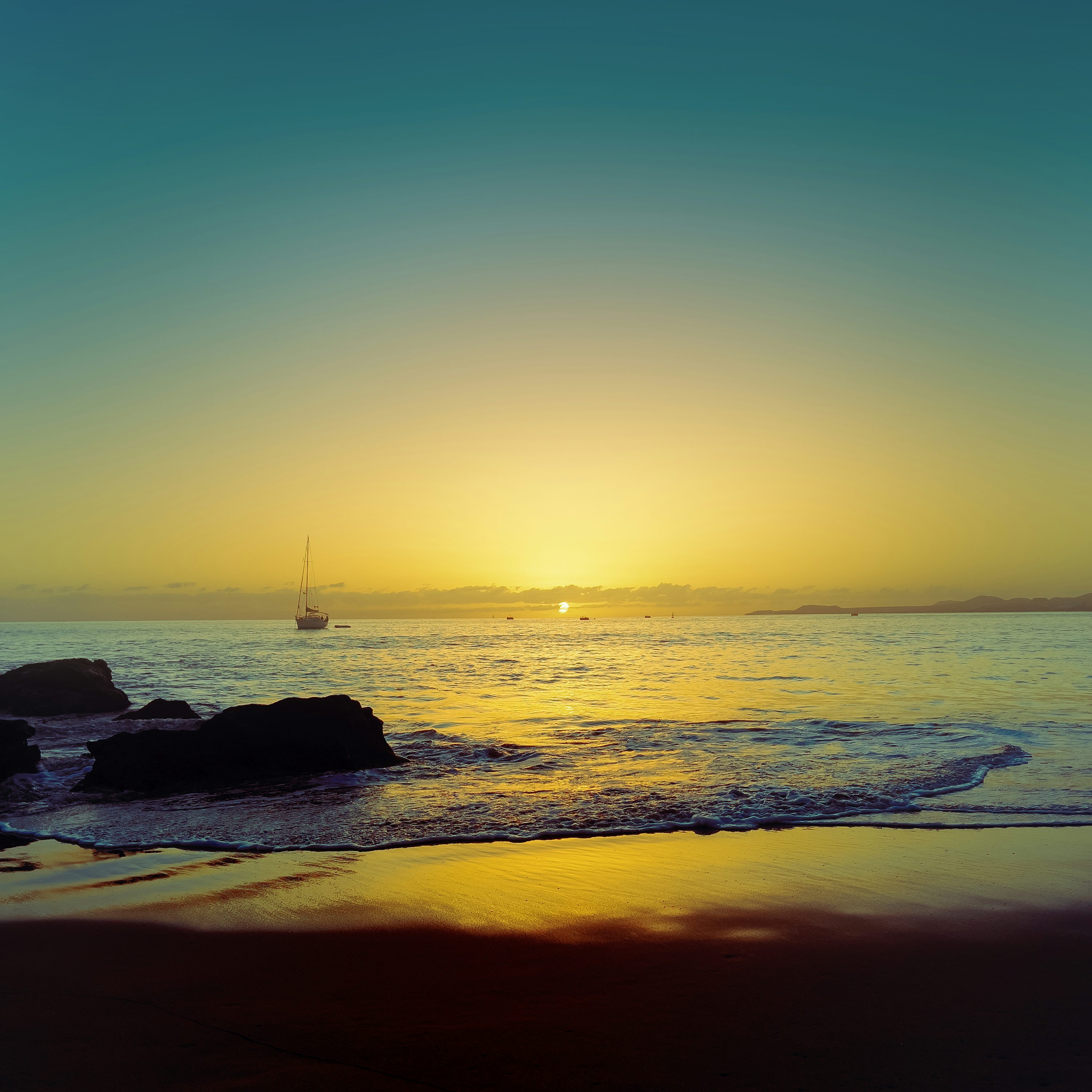 The sun is setting over the water at the beach photo