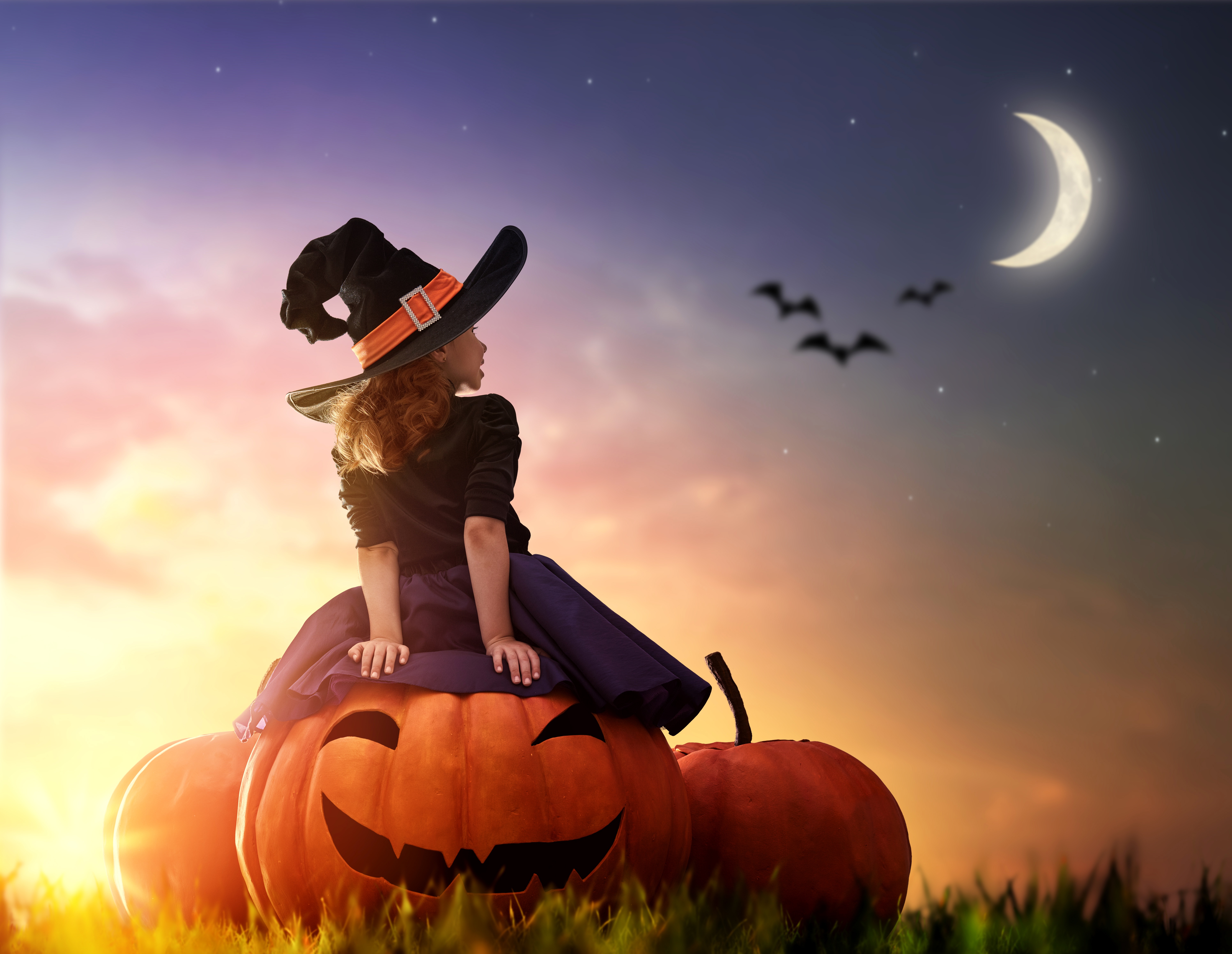 Halloween Magic: Child Witch on Pumpkin Under Moon in 4K Ultra HD Wallpaper