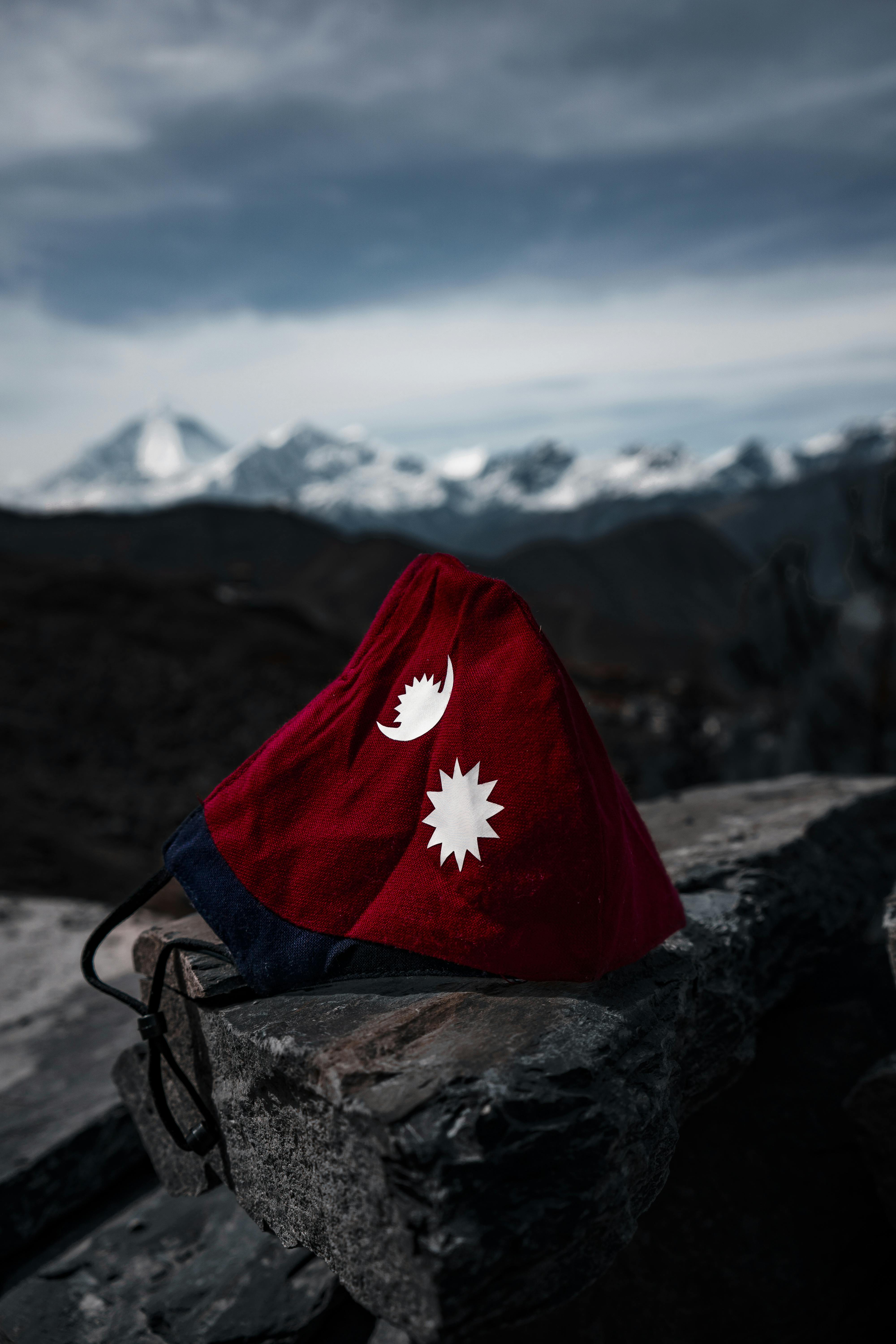 A Close Up Shot Of A Face Mask Designed From The Flag Of Nepal · Free