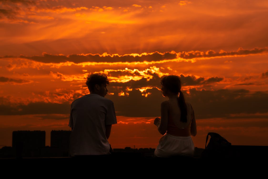 Couple Sitting Together at Sunset · Free