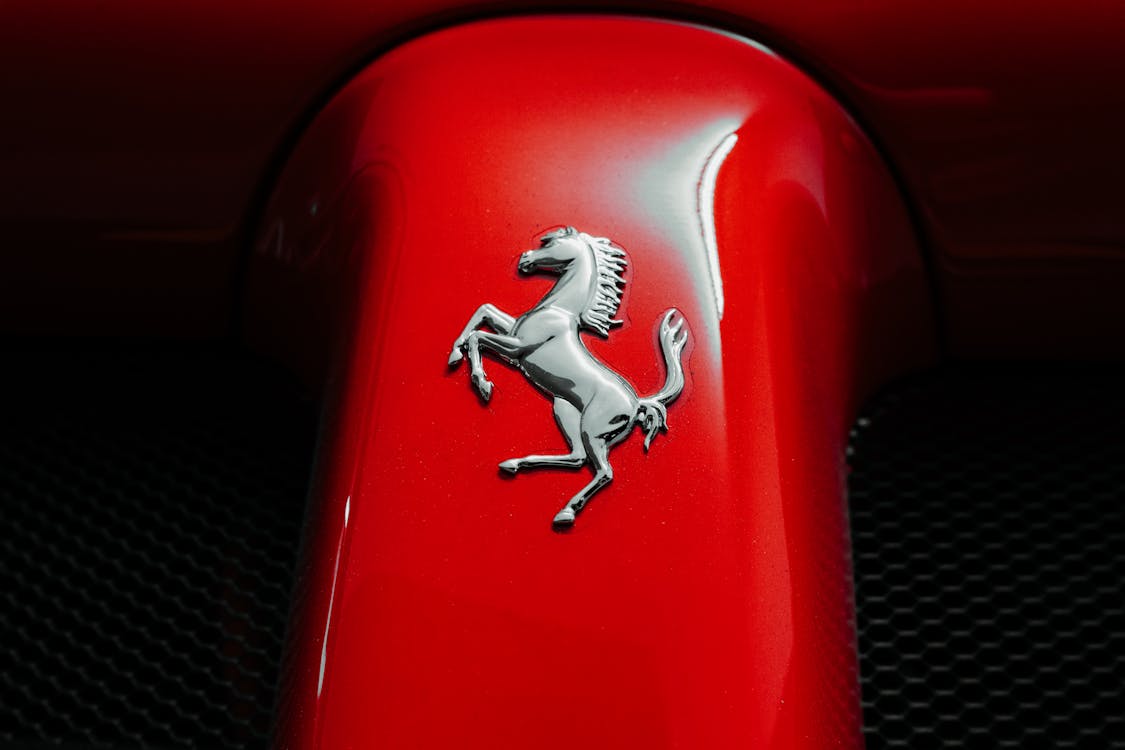 Close Up Of Iconic Prancing Horse Logo On Red Car · Free