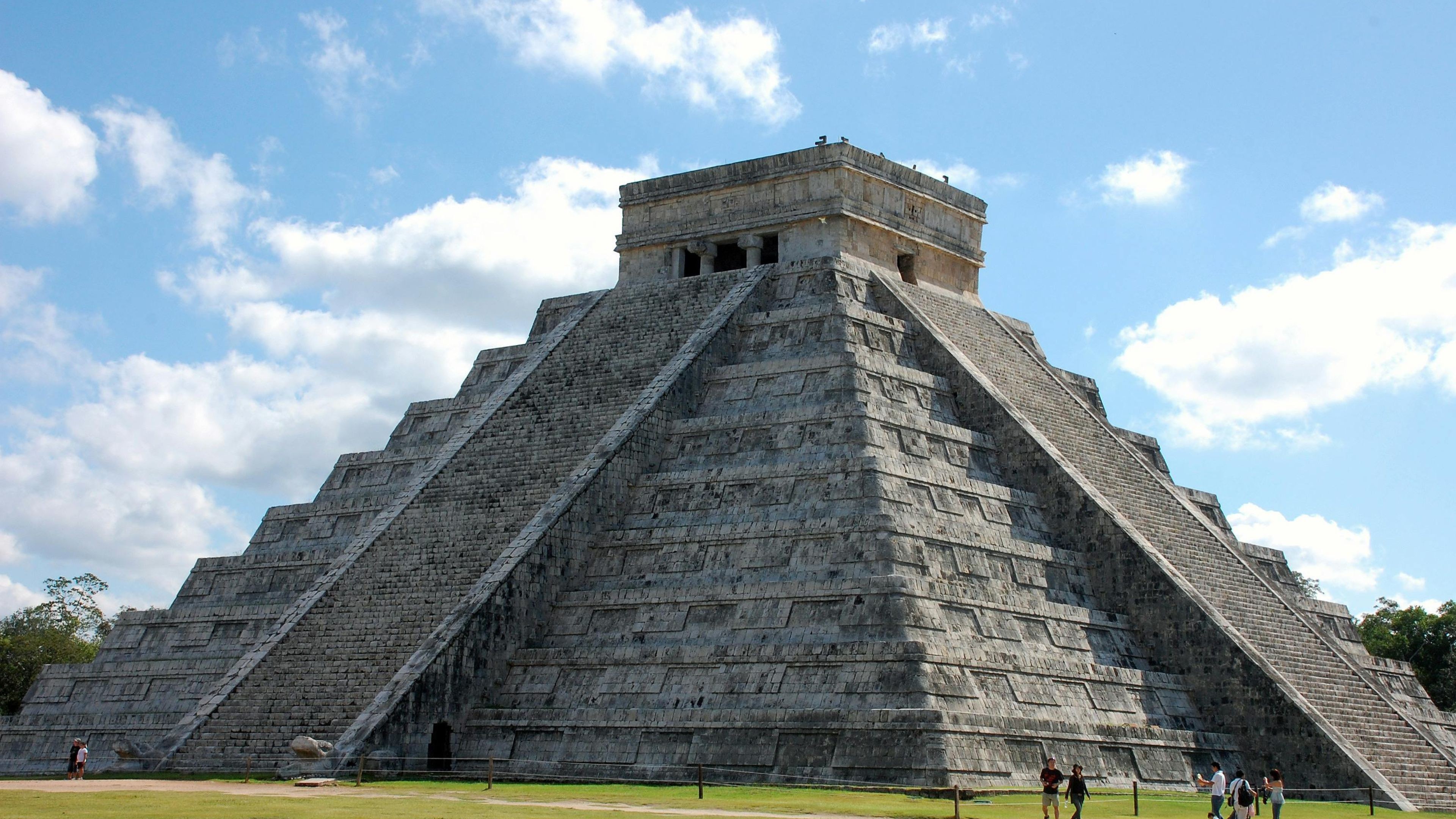 Chichen Itza mexico walking beside a pyramid clouds blue sky background 4K HD Travel Wallpaper