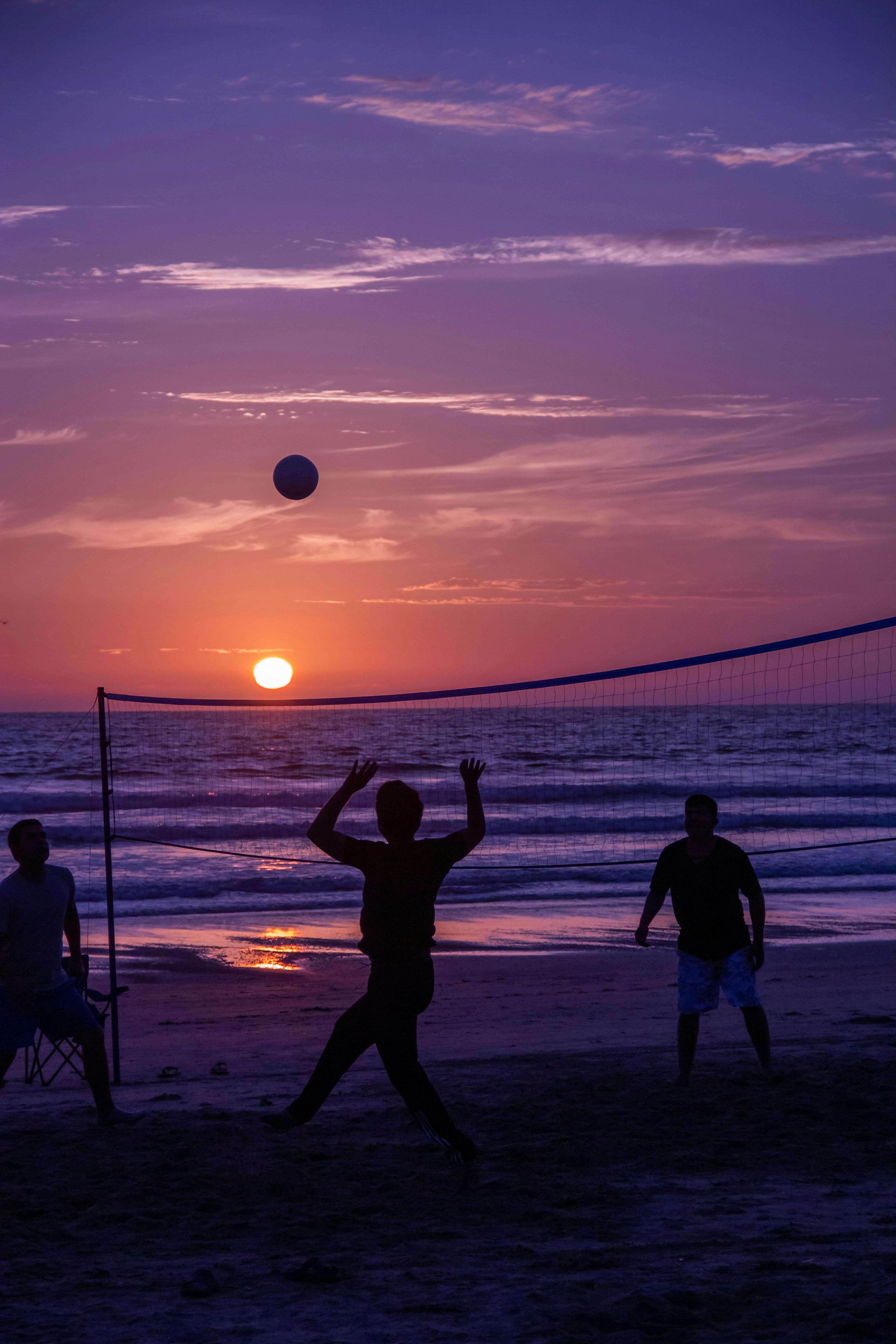 Photo of People Playing Volleyball on the Beach at Sunset · Free