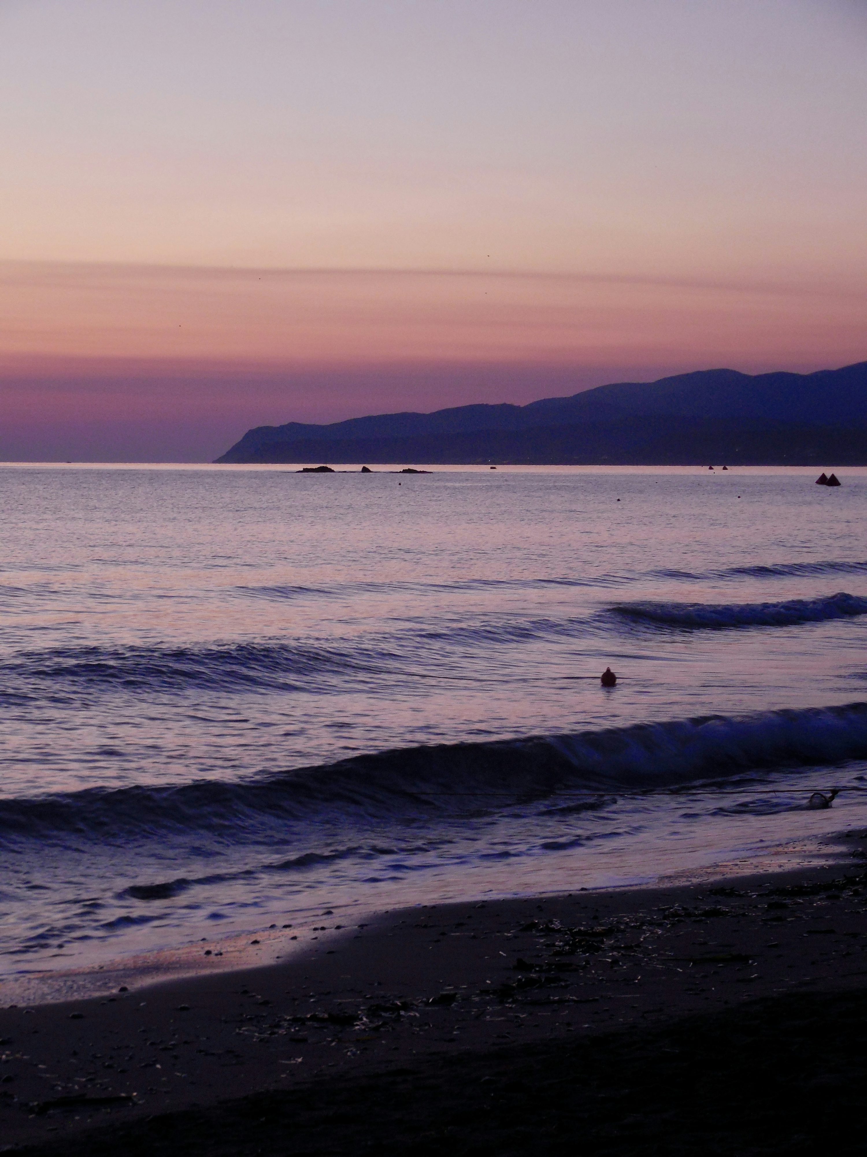 Purple sunset over a calm ocean and beach photo