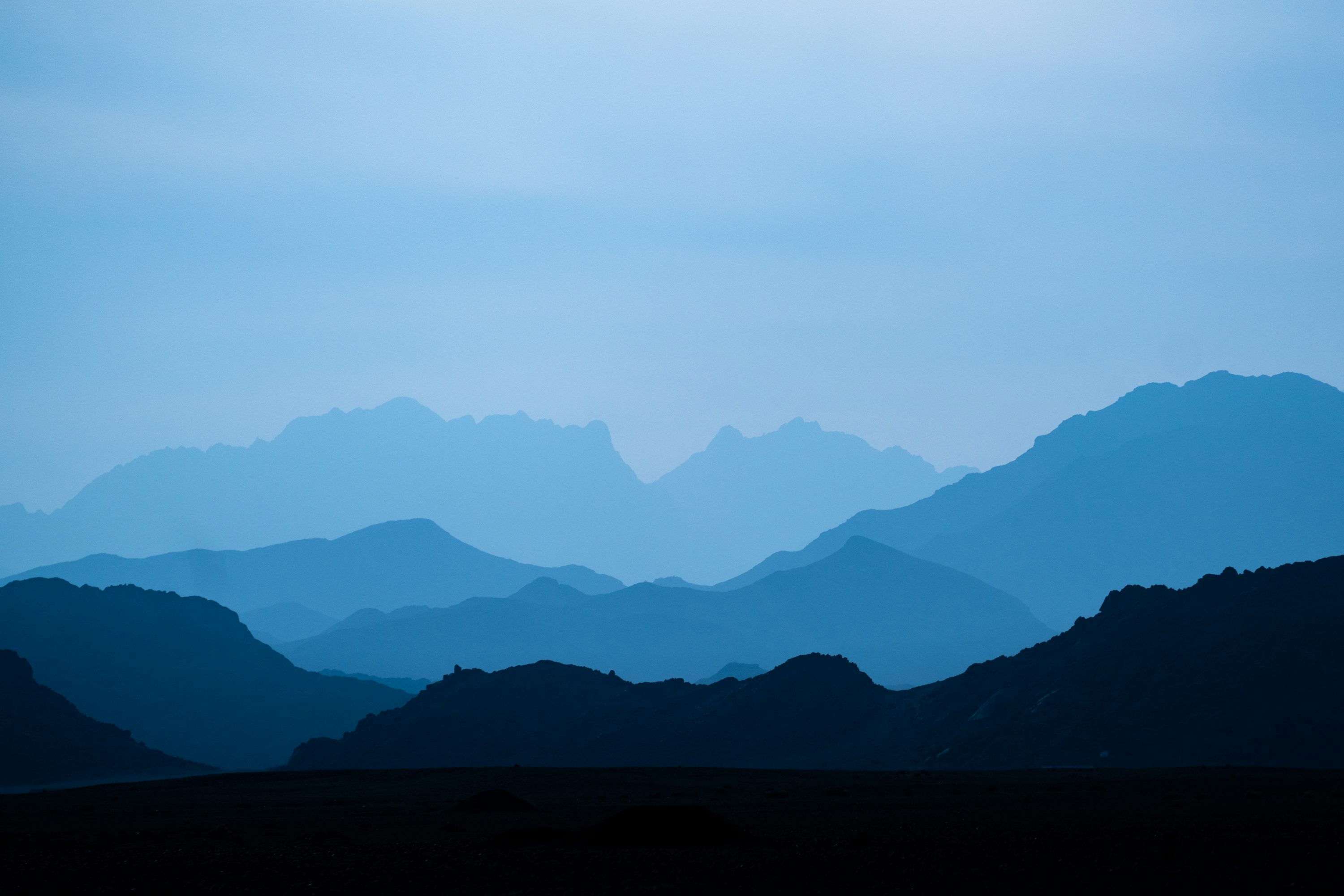 A mountain range with a blue sky in the background photo