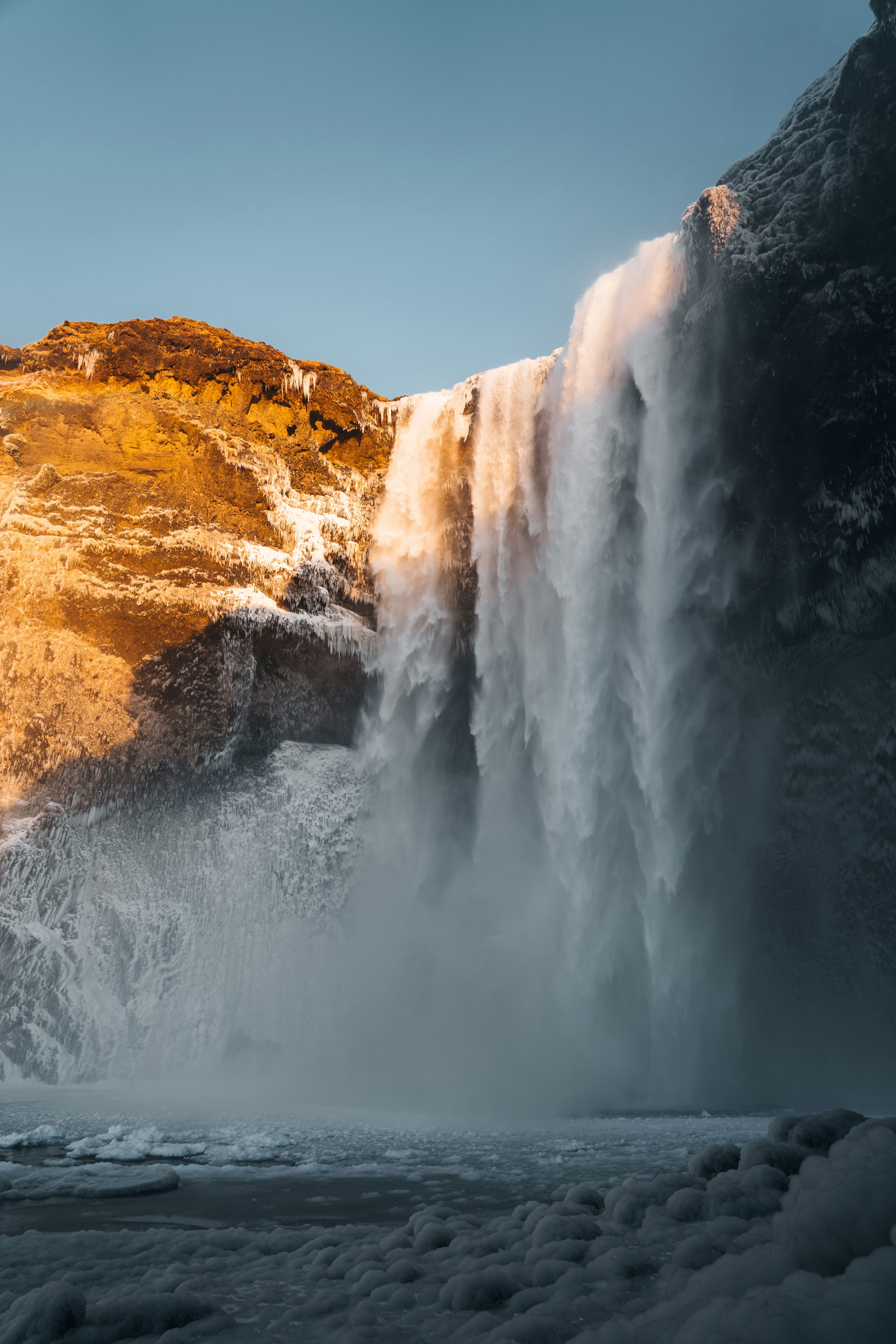 A large waterfall over a snow covered mountain photo