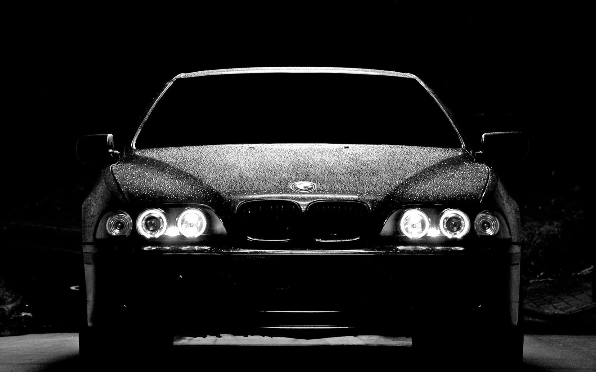 Laconic BMW M5 at night with the headlights on for your phone