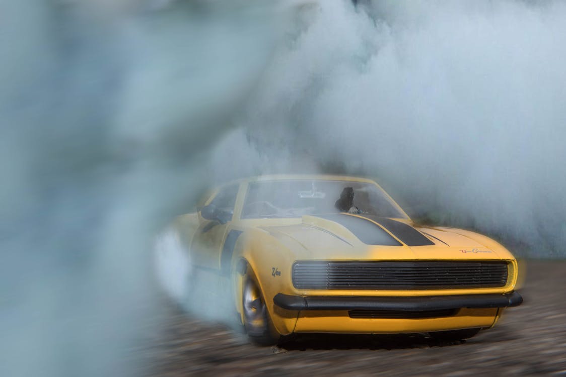 Classic Yellow And Black Sports Car Drifting On Road With Smoke · Free