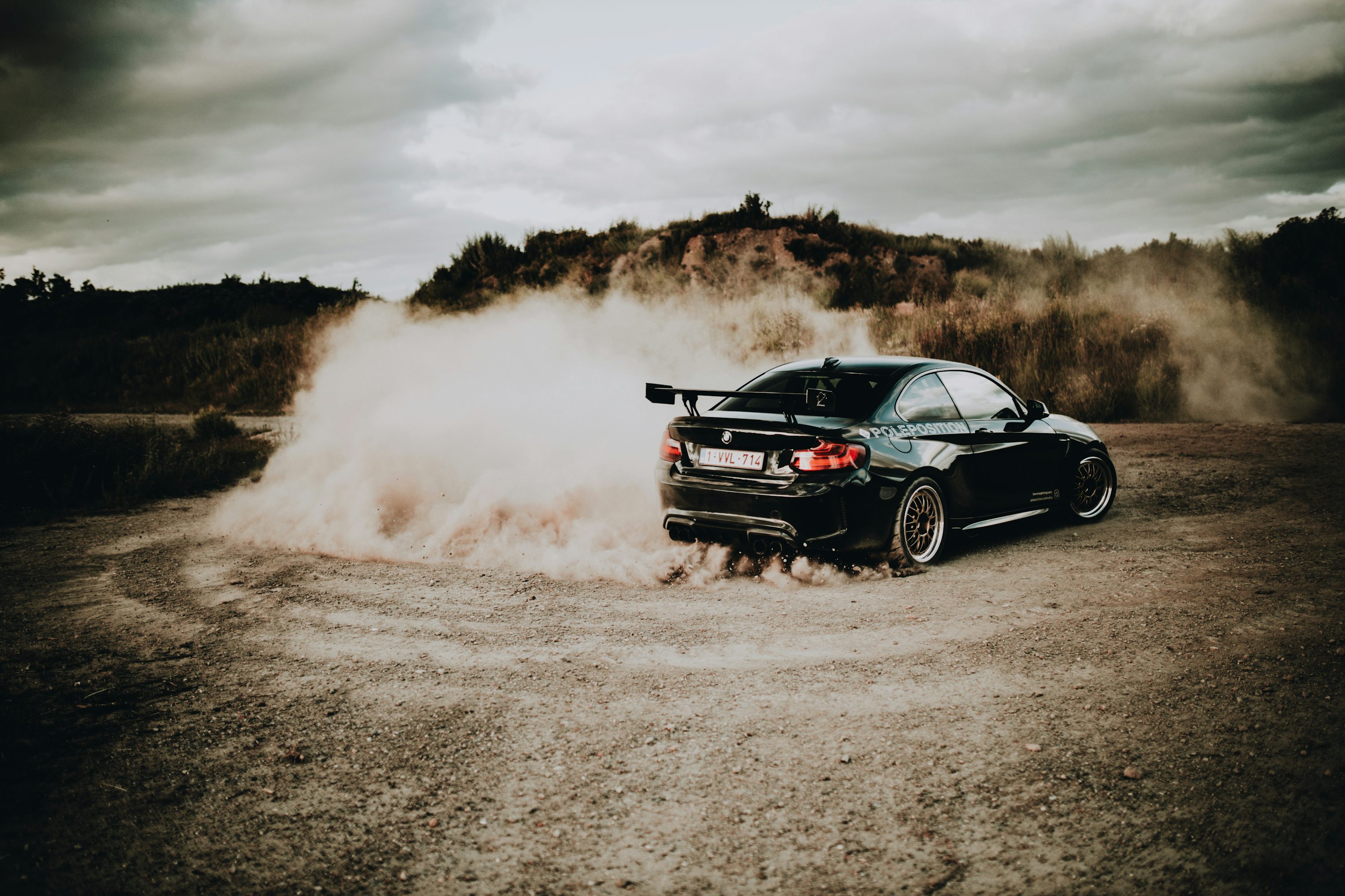 Black chevrolet camaro on brown field during daytime photo