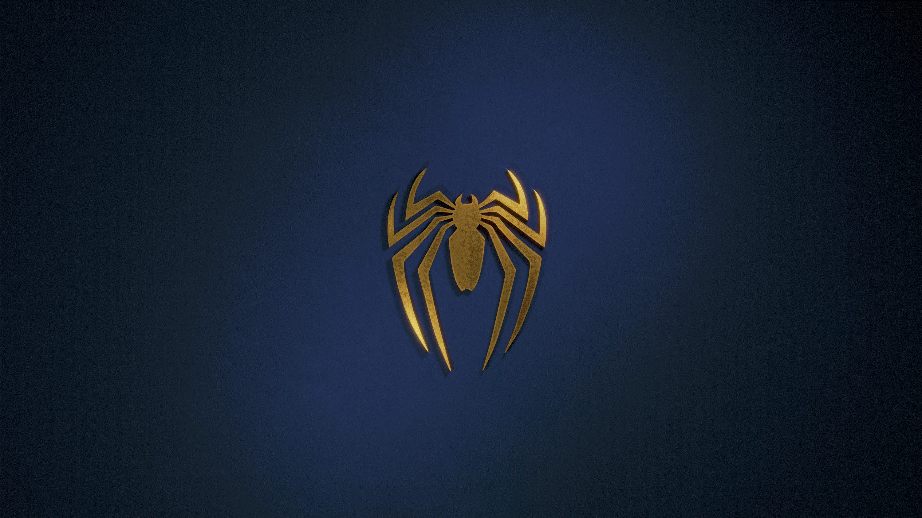 A golden spider logo on a dark blue background photo