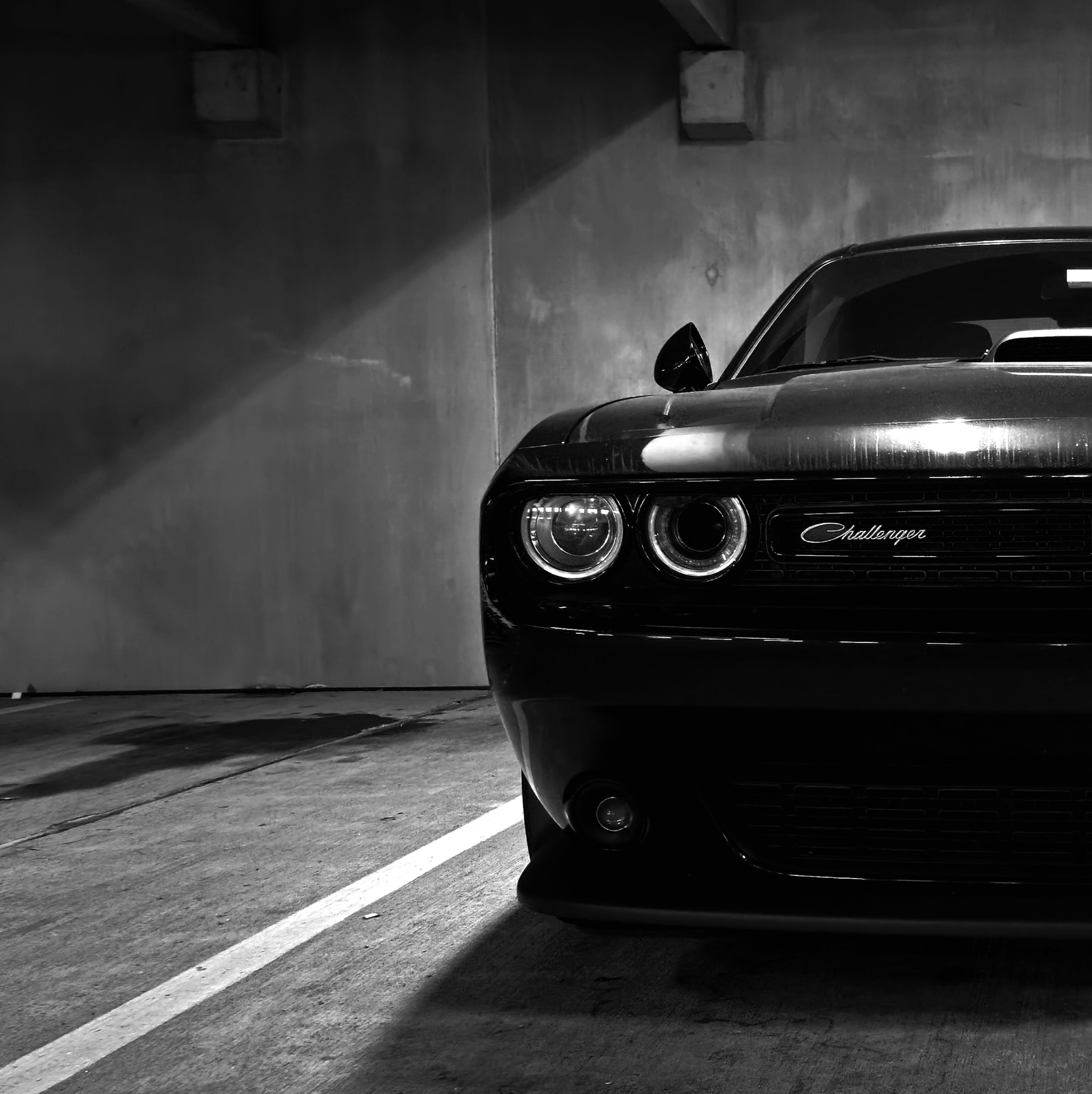 A black and white photo of a car in a parking garage photo