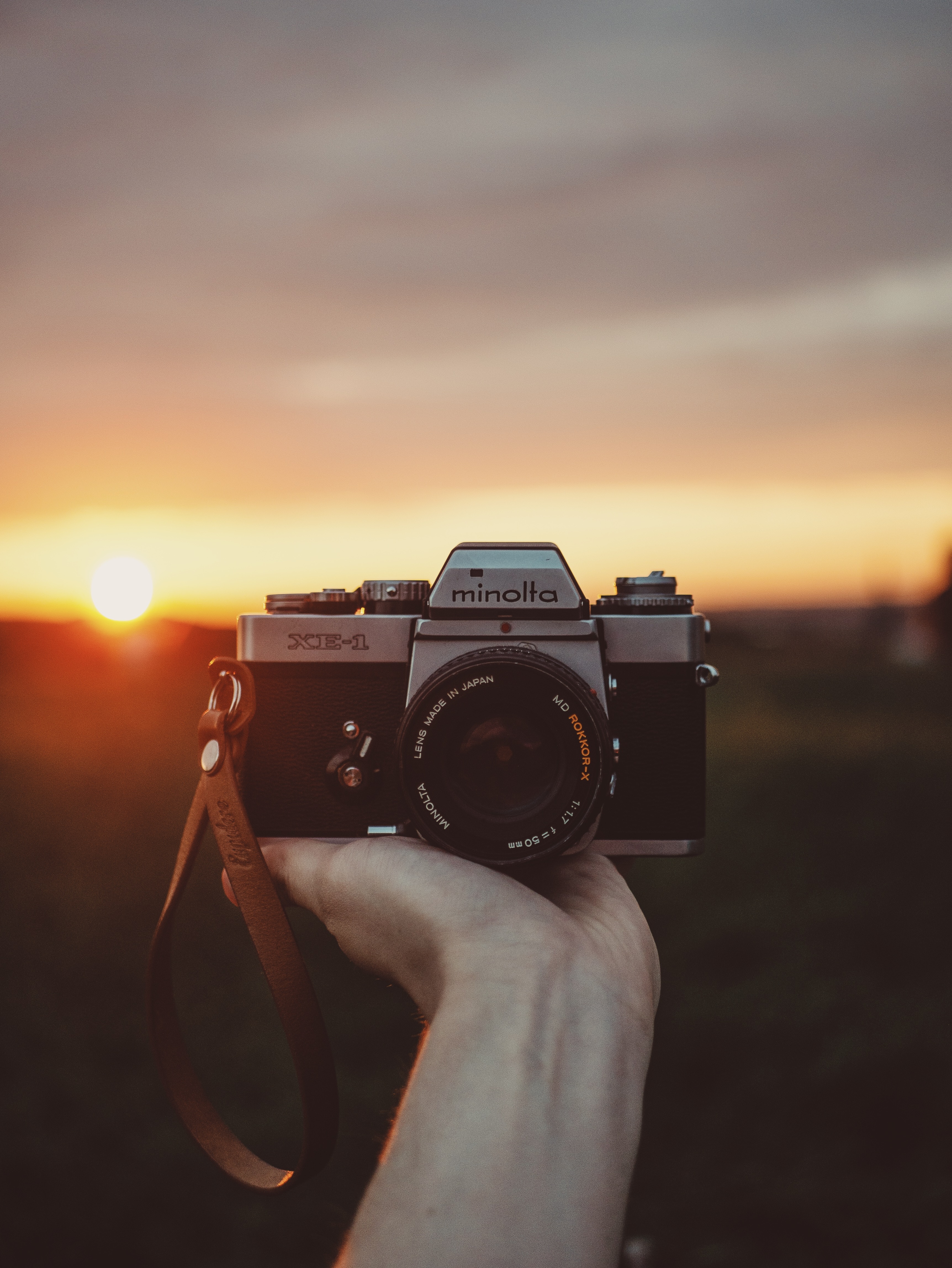 Download wallpaper 3448x4592 camera, hand, sunset, photographer HD background