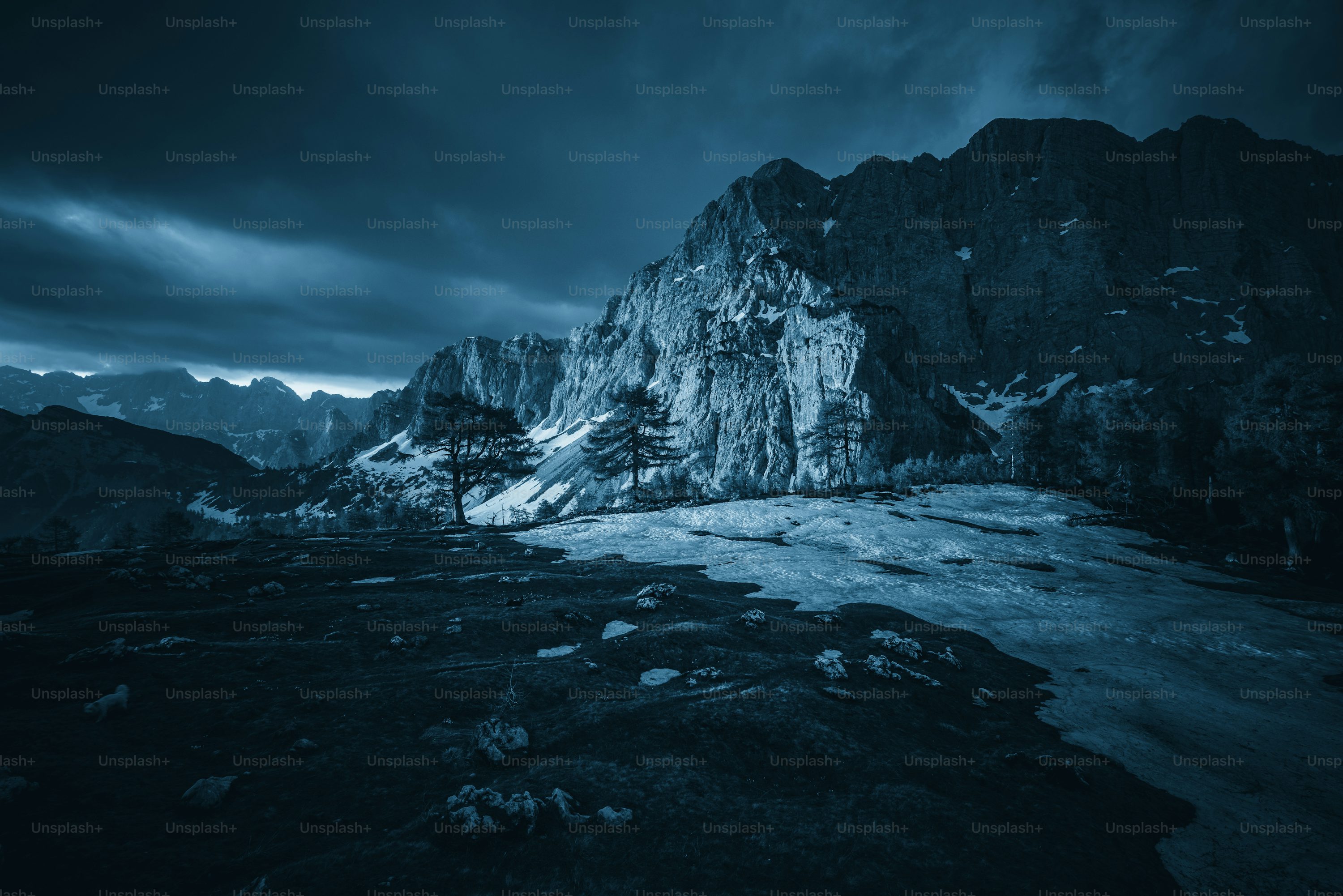 A snowy mountain with a dark sky in the background photo