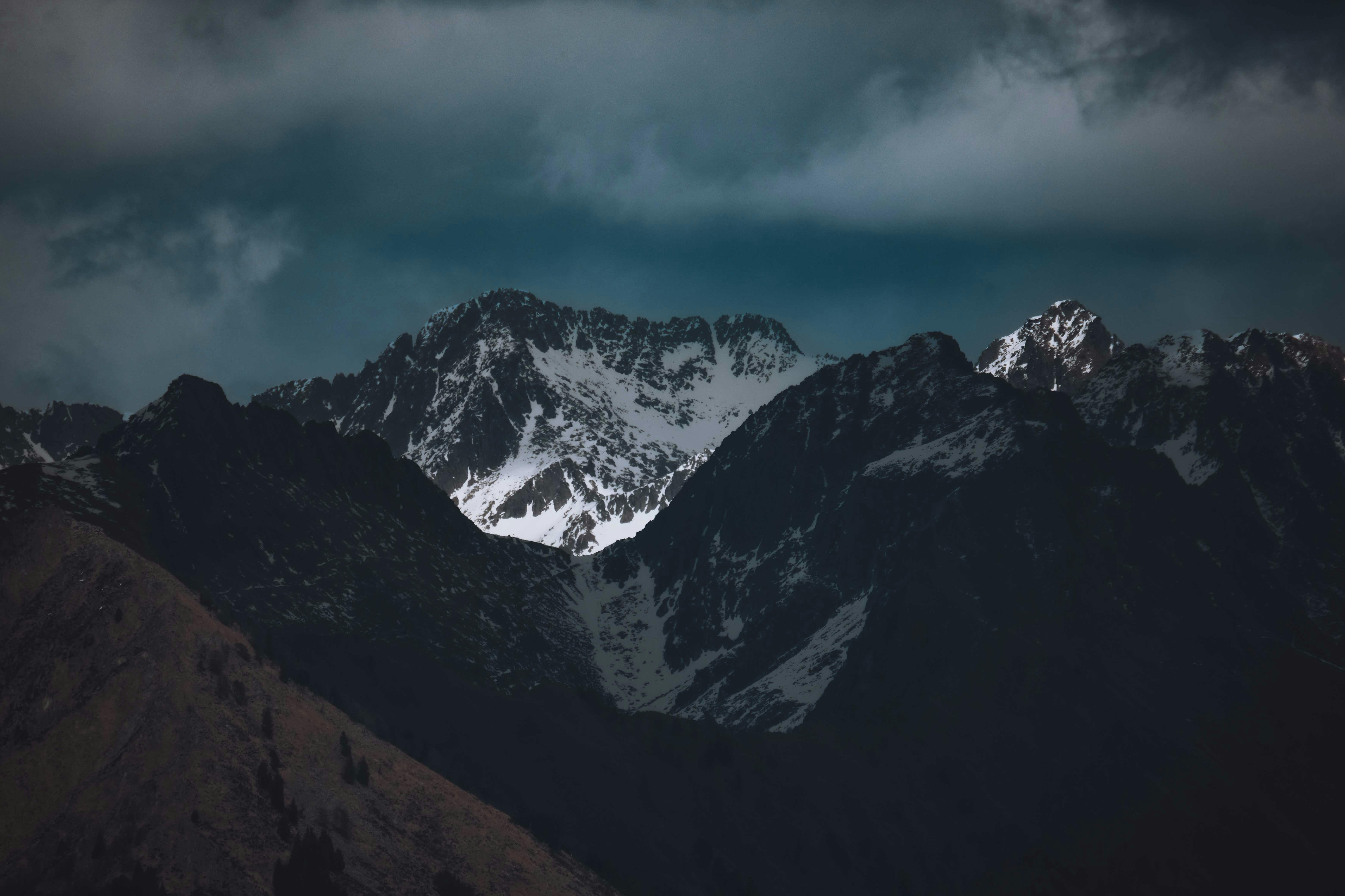 Snow Covered Mountain Under Dark Cloudy Sky · Free