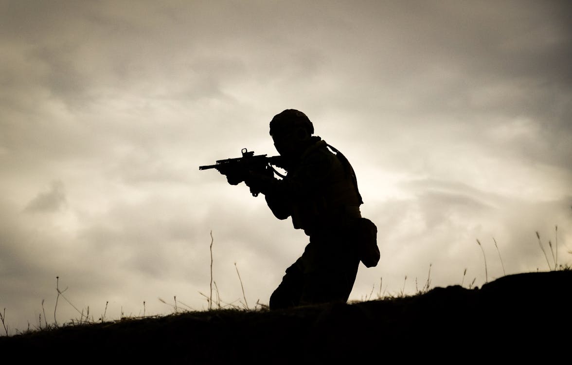 A Man in Black Jacket Holding a Rifle · Free