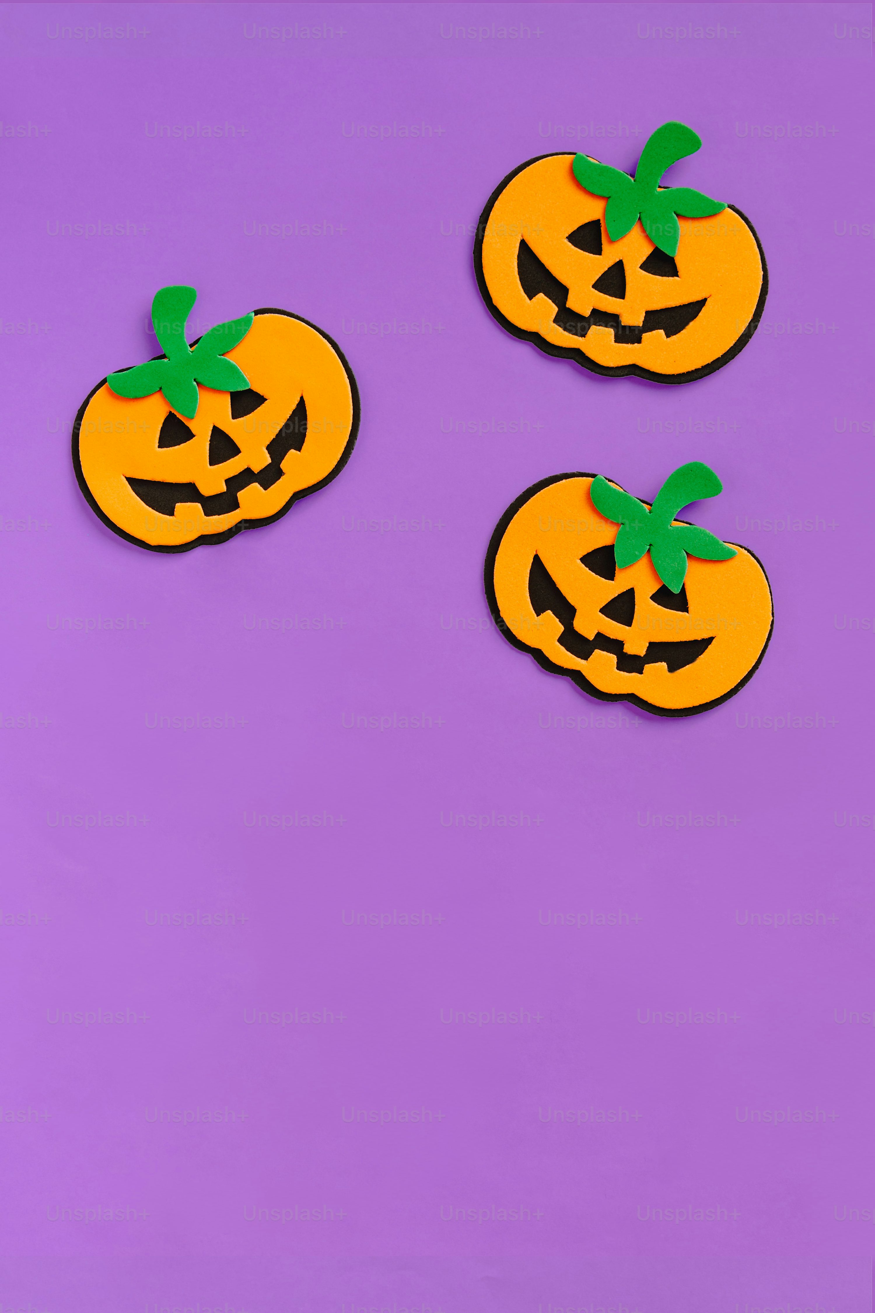 Three orange pumpkins on a purple background photo