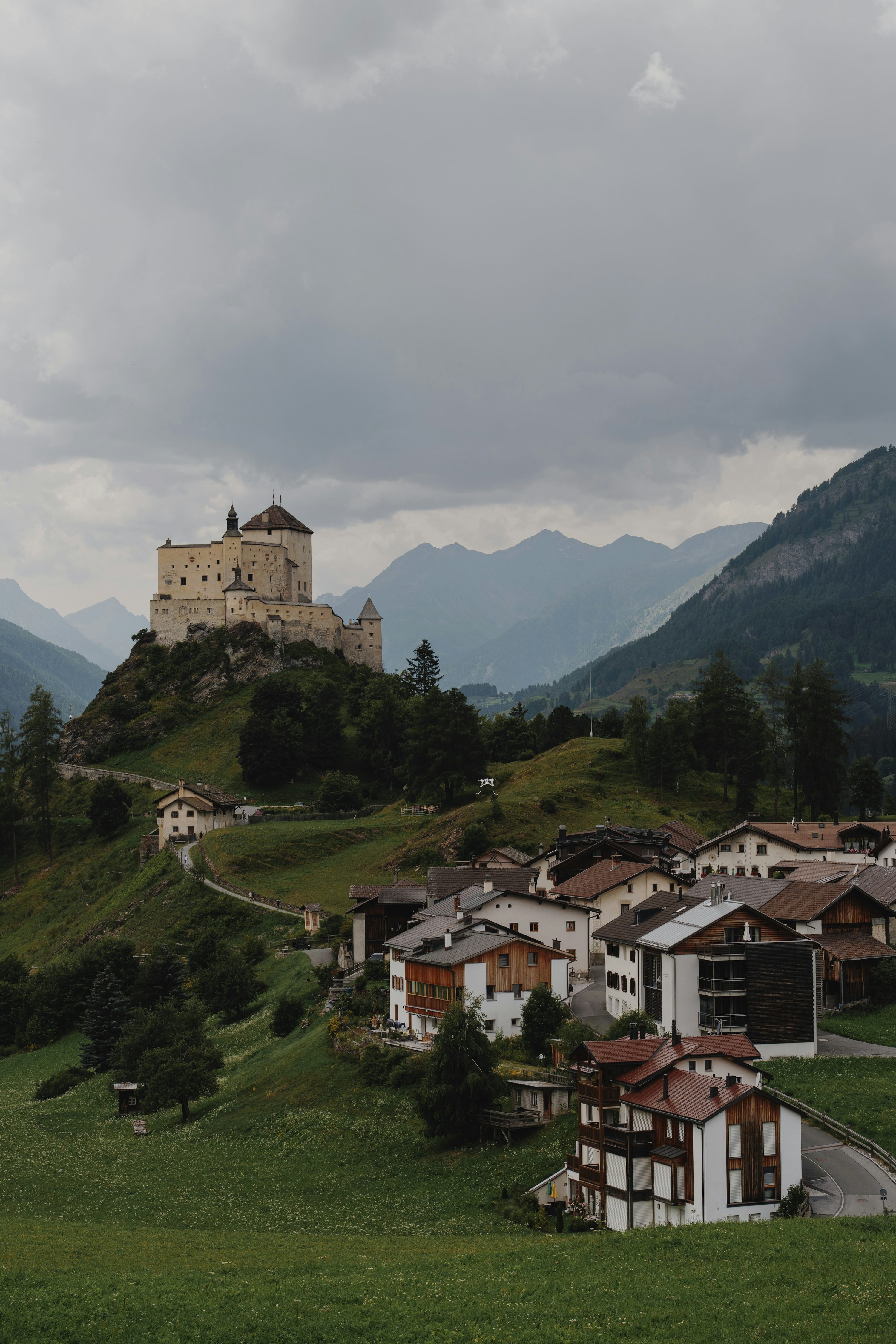 A castle overlooks a village in the mountains. photo