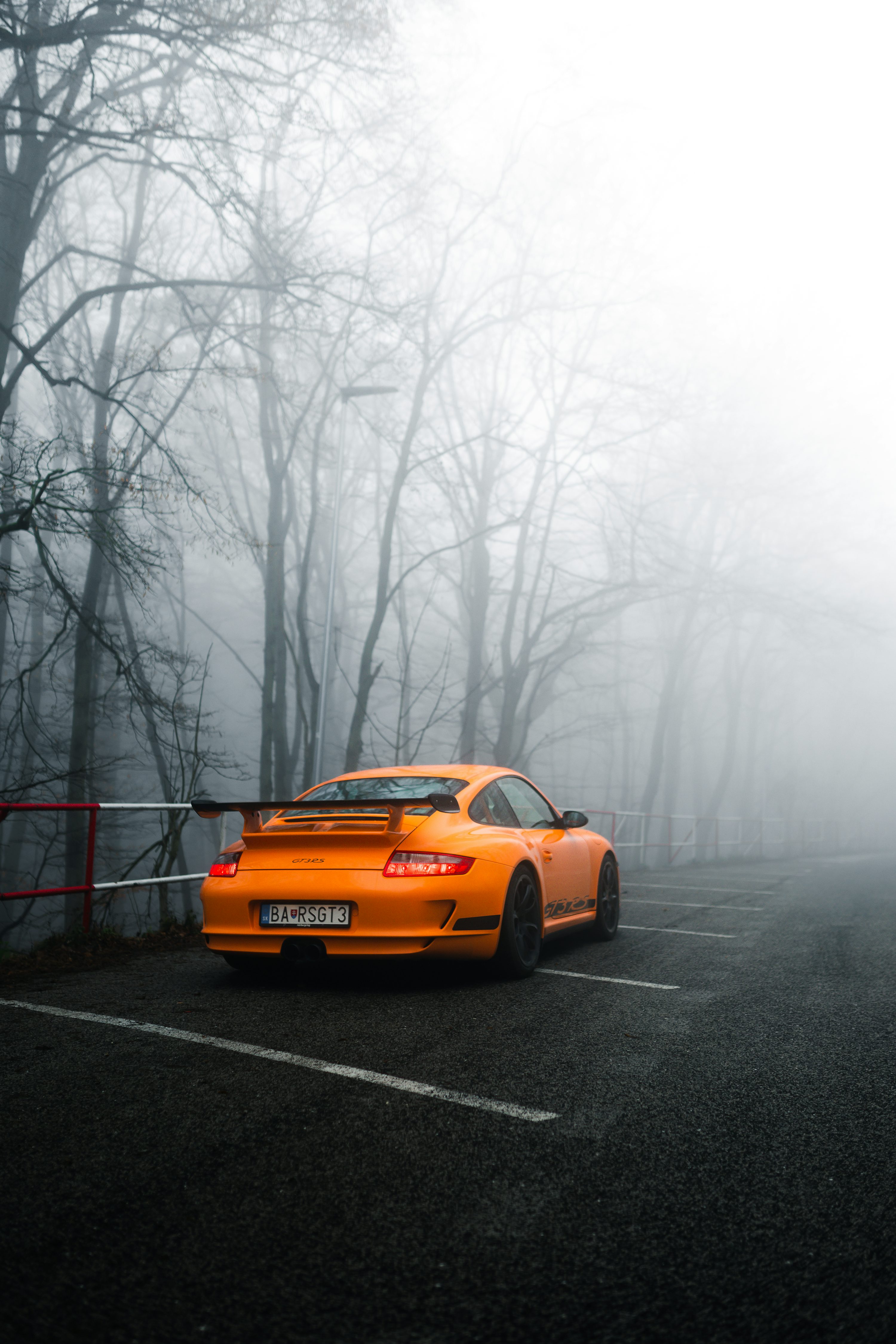 An orange sports car parked in a parking lot photo